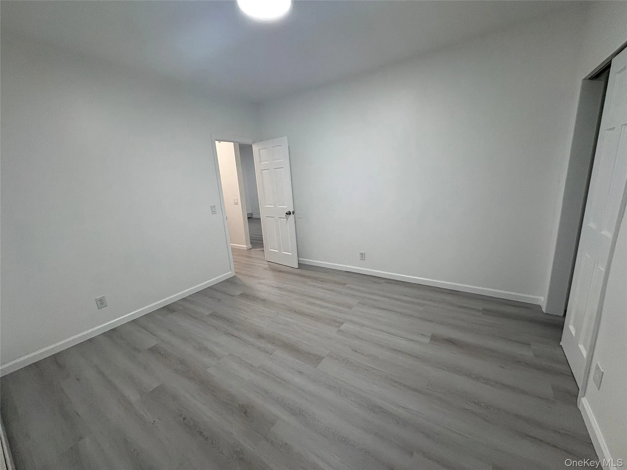 Spacious bedroom featuring new flooring, fresh paint, and plenty of natural light. Spacious bedroom featuring new flooring, fresh paint, and plenty of natural light.