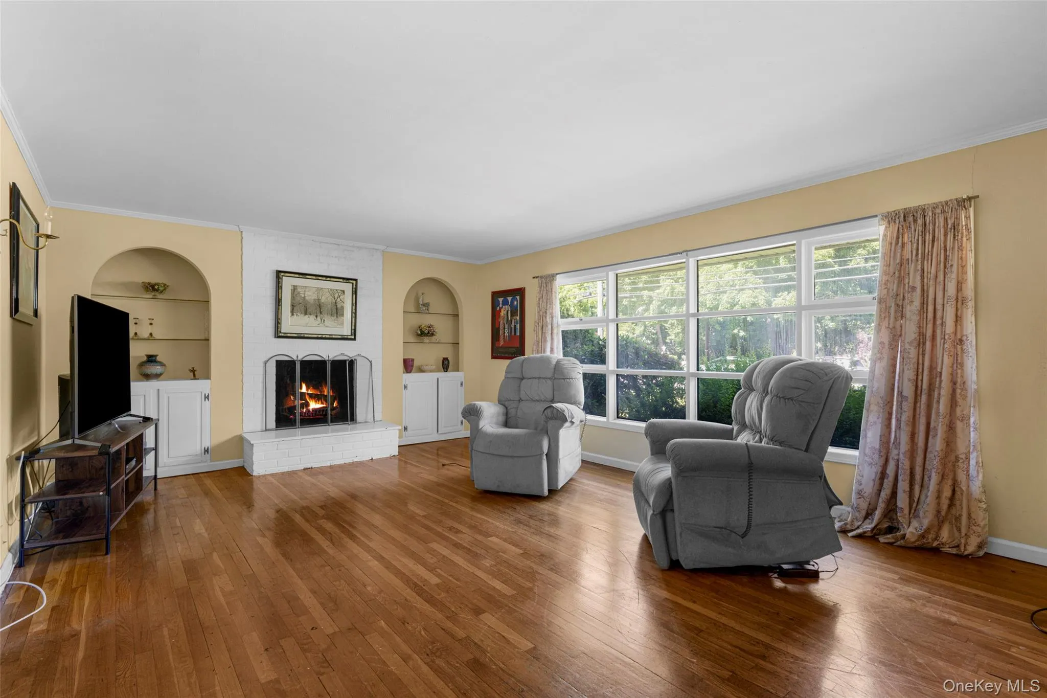 Living room boasts expansive front window, wood burning Fireplace, Built-ins with Cabinets and shelving. Living room boasts expansive front window, wood burning Fireplace, Built-ins with Cabinets and shelving.