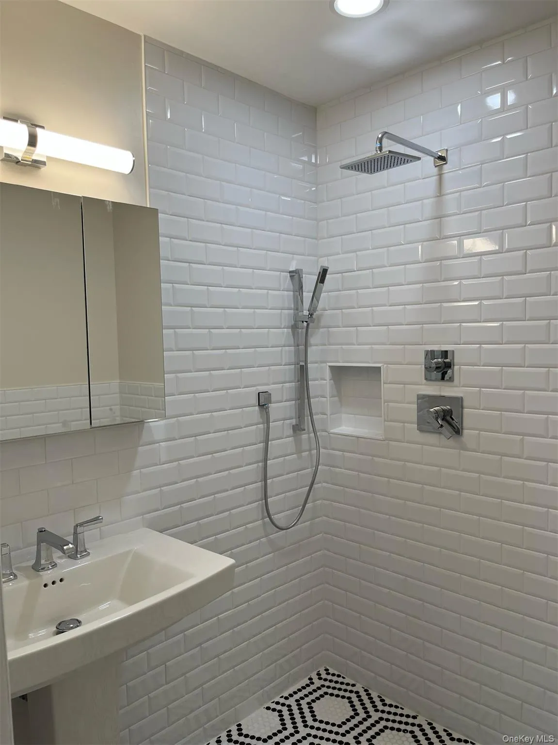 Bathroom featuring a tile shower and tile walls, rain shower head Bathroom featuring a tile shower and tile walls, rain shower head
