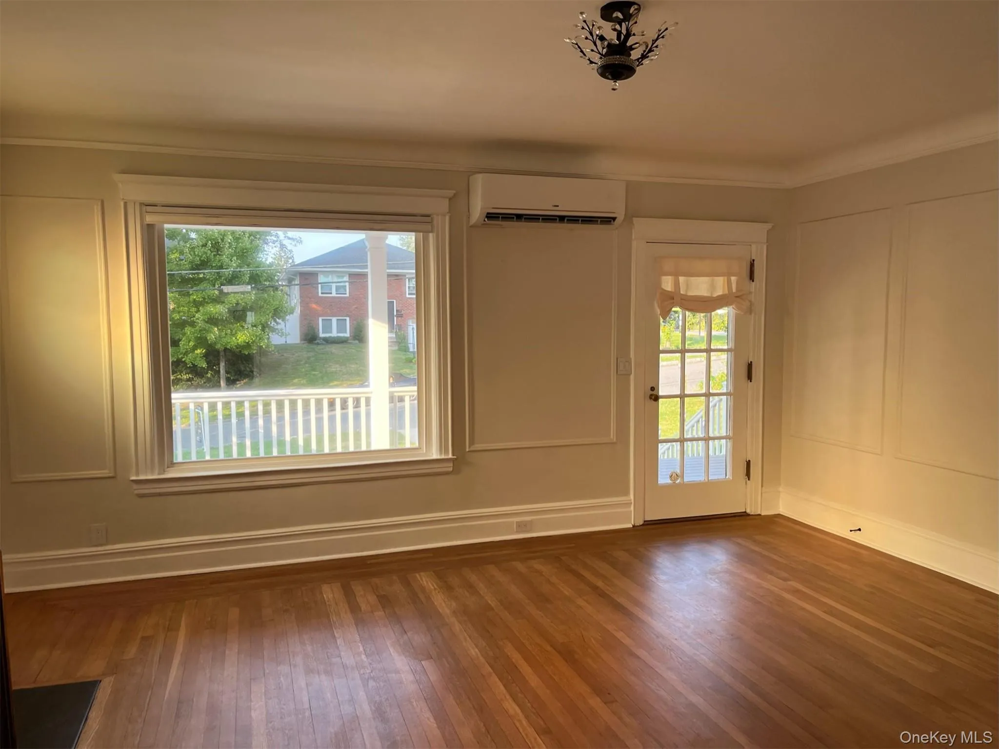 Living room featuring ductless a/c and heat, wood floors, ornamental molding, baseboards Living room featuring ductless a/c and heat, wood floors, ornamental molding, baseboards