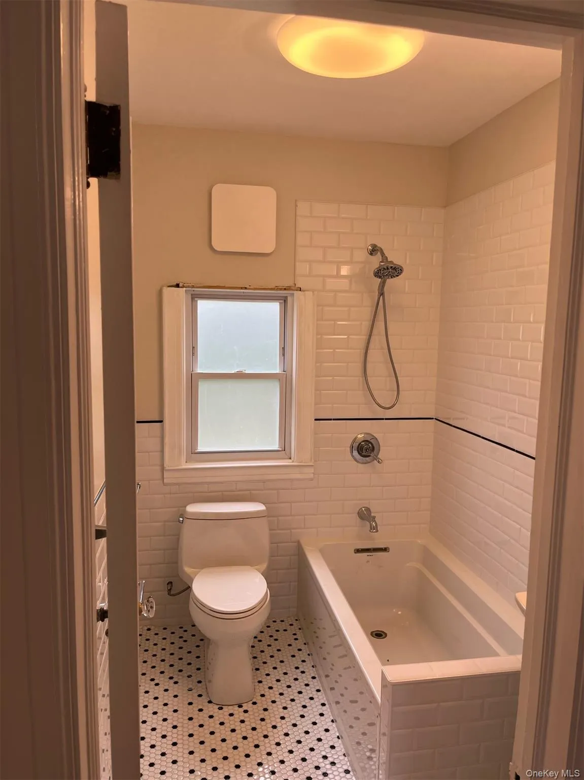 Bathroom featuring low flow toilet, shower / tub combination, tile walls, Bathroom featuring low flow toilet, shower / tub combination, tile walls,
