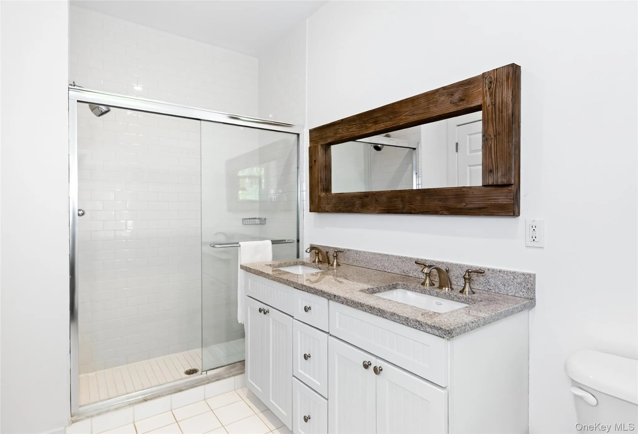 Double vanity with granite countertop and dual undermount sinks, featuring bronze-finish fixtures Double vanity with granite countertop and dual undermount sinks, featuring bronze-finish fixtures