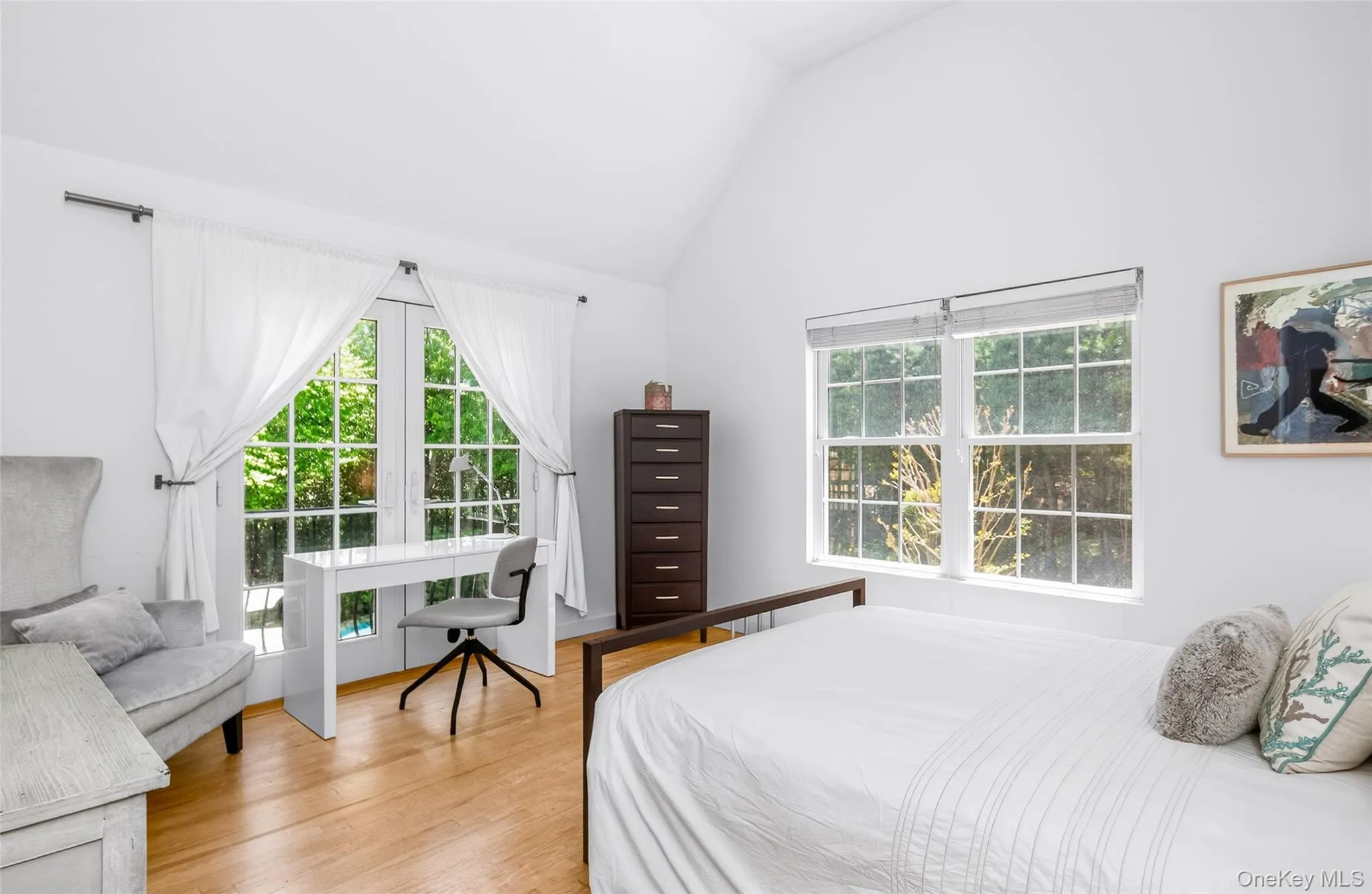 Vaulted ceilings enhance this Bedroom with Juliet balcony featuring French doors, and a double window Vaulted ceilings enhance this Bedroom with Juliet balcony featuring French doors, and a double window