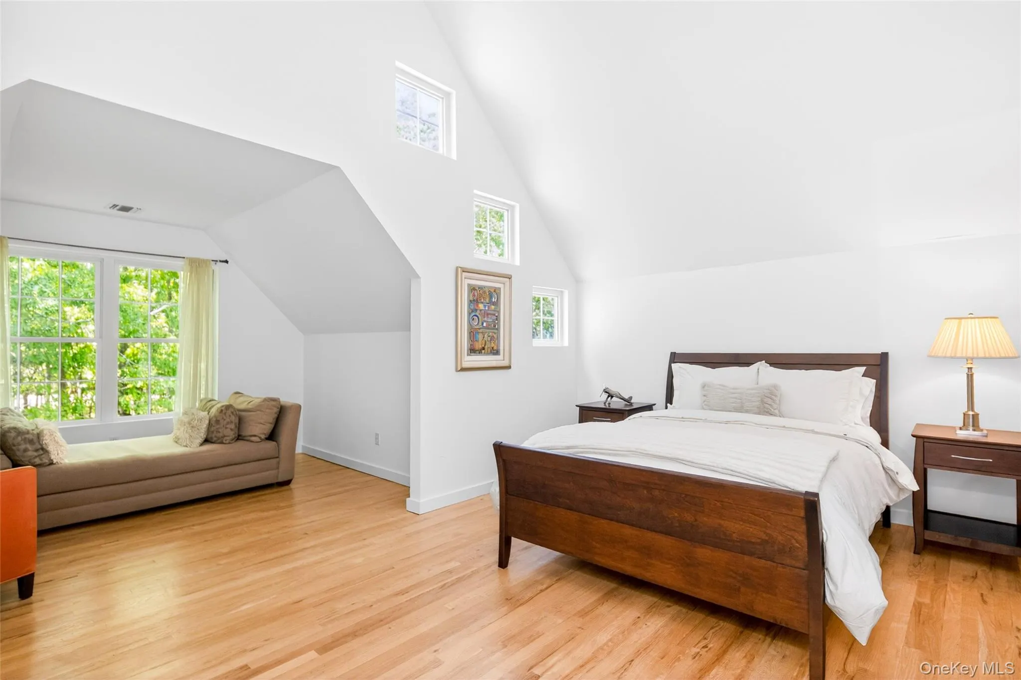 Spacious Jr Primary Bedroom featuring light wood-finish flooring and multiple windows Spacious Jr Primary Bedroom featuring light wood-finish flooring and multiple windows