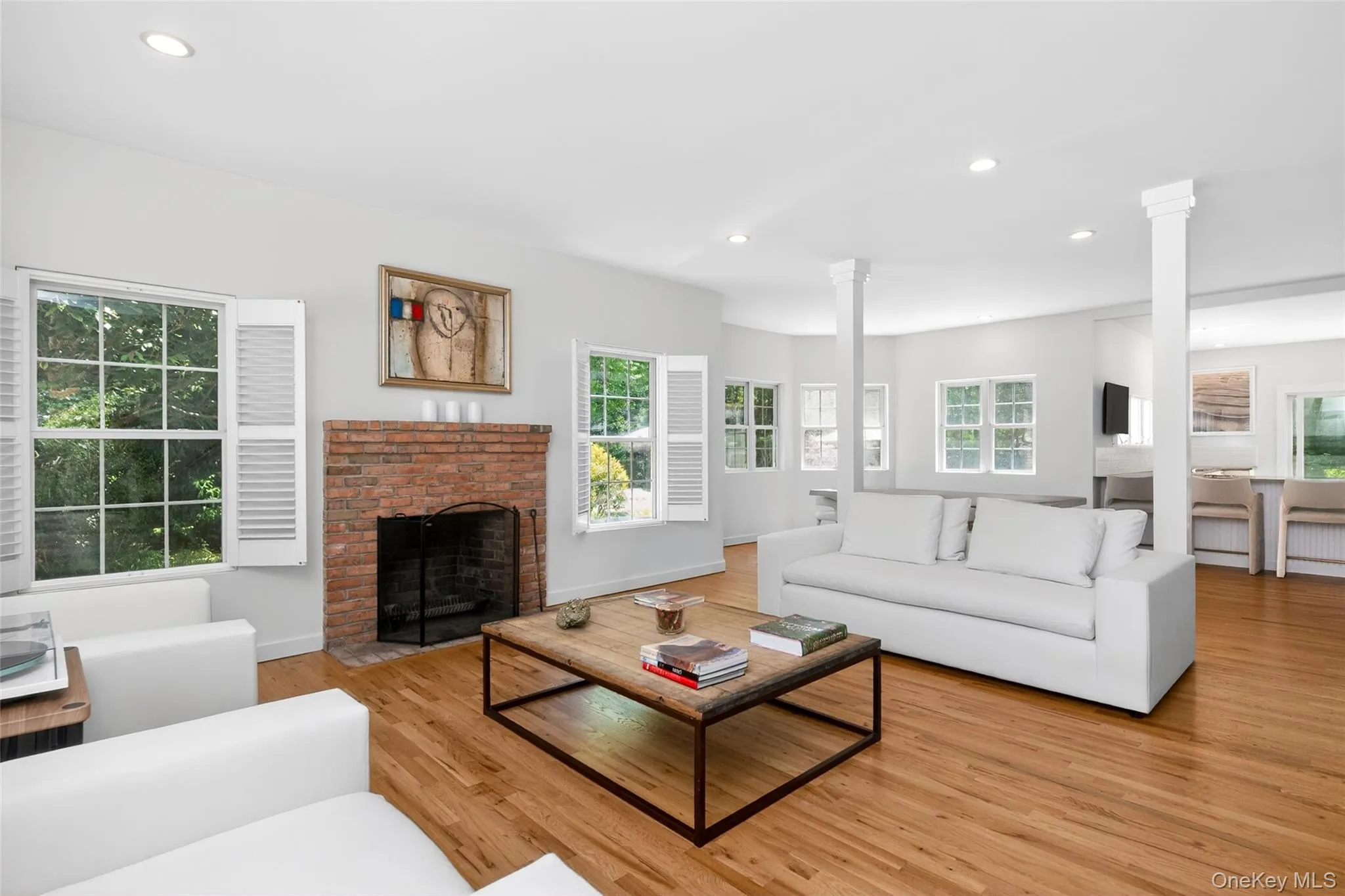Living area featuring wood-finish flooring and a brick fireplace Living area featuring wood-finish flooring and a brick fireplace