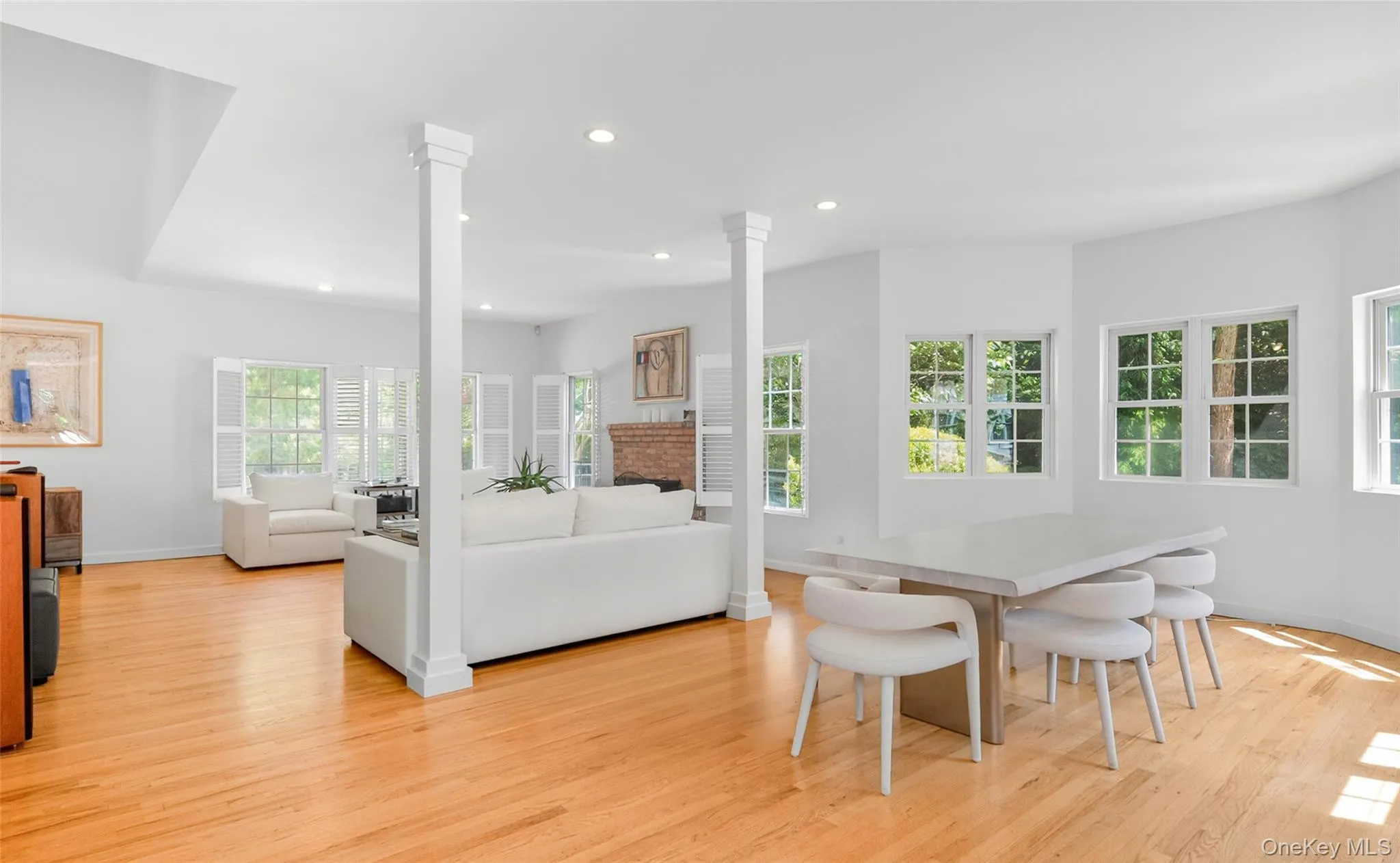 Light wood-finish flooring throughout, featuring a white dining table with matching chairs Light wood-finish flooring throughout, featuring a white dining table with matching chairs