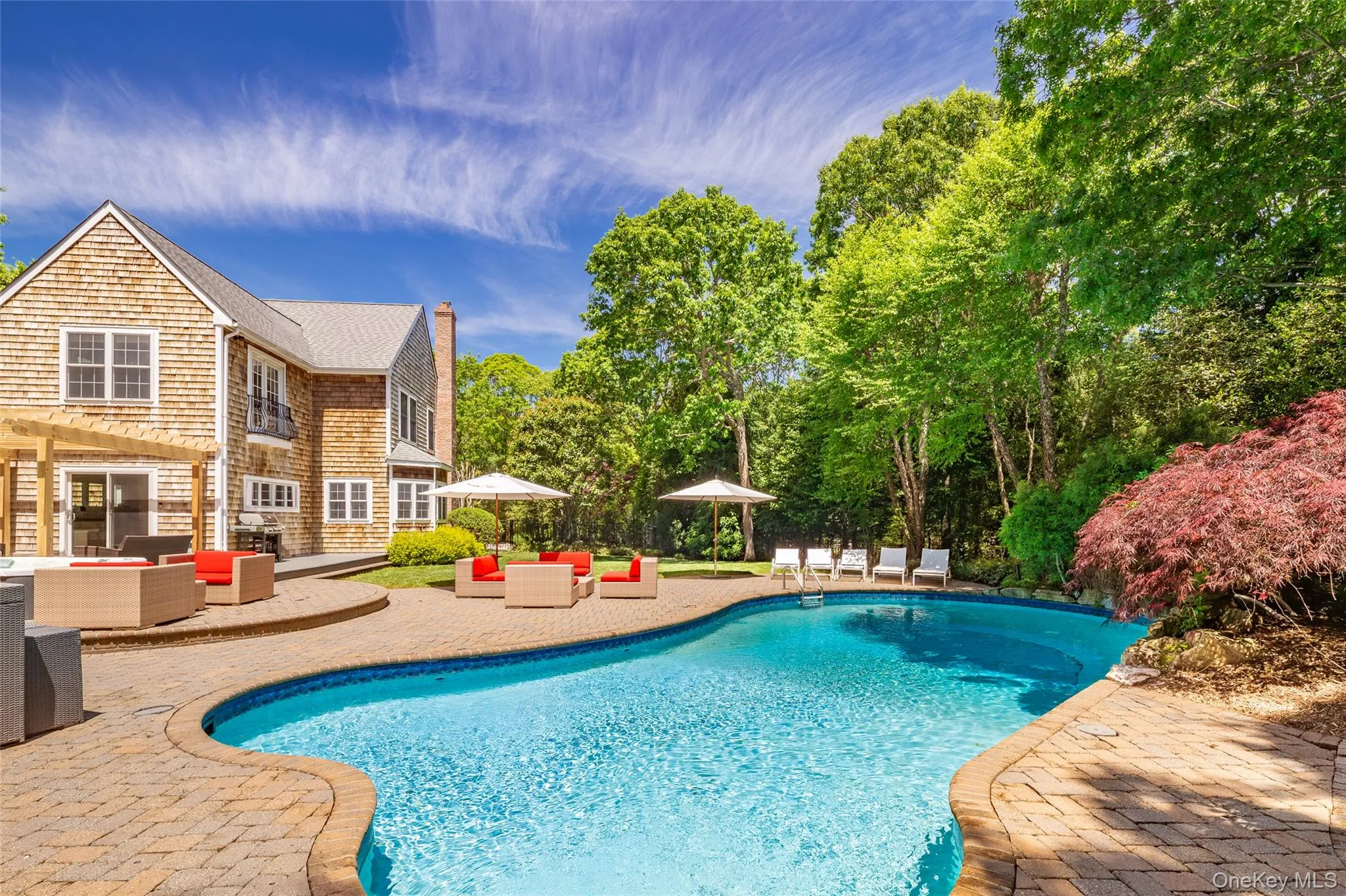 Freeform swimming pool surrounded by a paver patio Freeform swimming pool surrounded by a paver patio