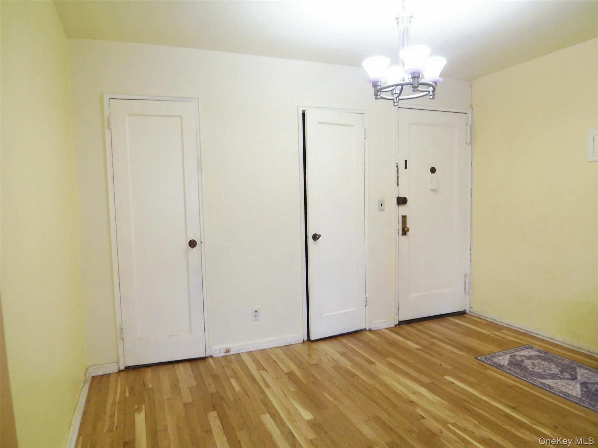 Hardwood-finish flooring extends through this space, complemented by a multi-bulb ceiling fixture Hardwood-finish flooring extends through this space, complemented by a multi-bulb ceiling fixture