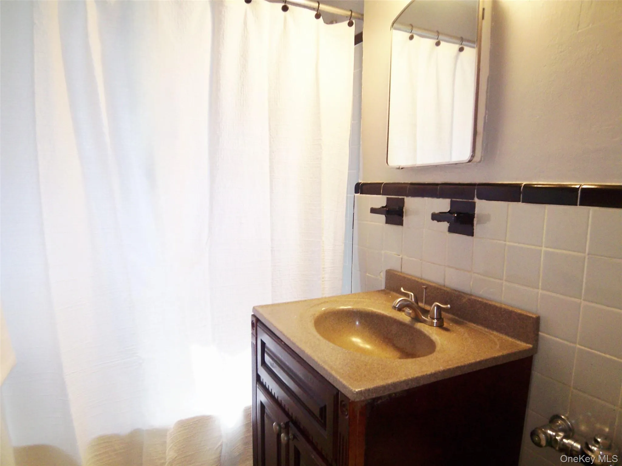 Bathroom vanity with a tan countertop and integrated sink, dark wood-finish cabinetry, and chrome-finish faucet Bathroom vanity with a tan countertop and integrated sink, dark wood-finish cabinetry, and chrome-finish faucet