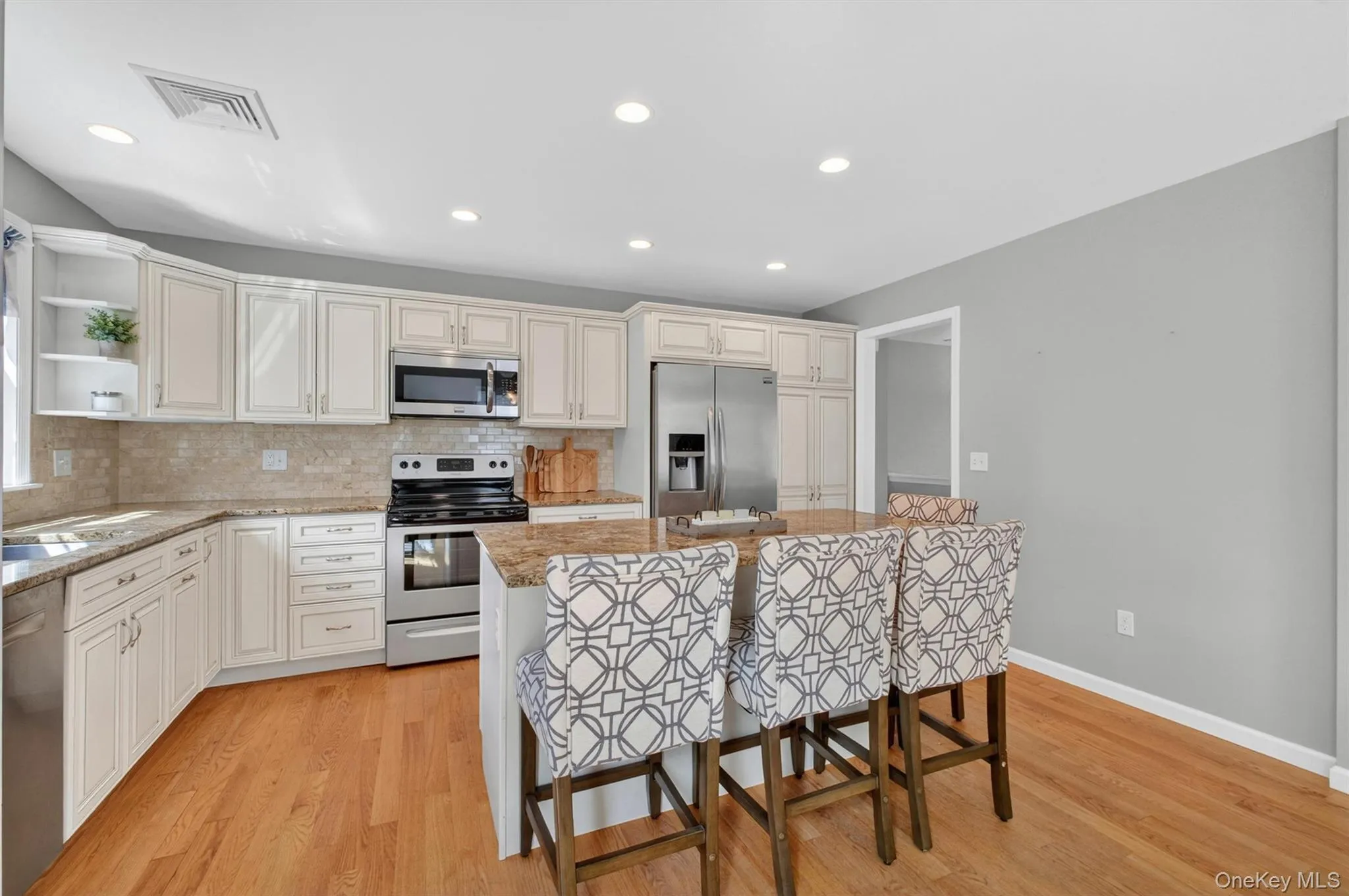 The gourmet kitchen features custom cabinets, a large island with seating and granite countertops. The gourmet kitchen features custom cabinets, a large island with seating and granite countertops.