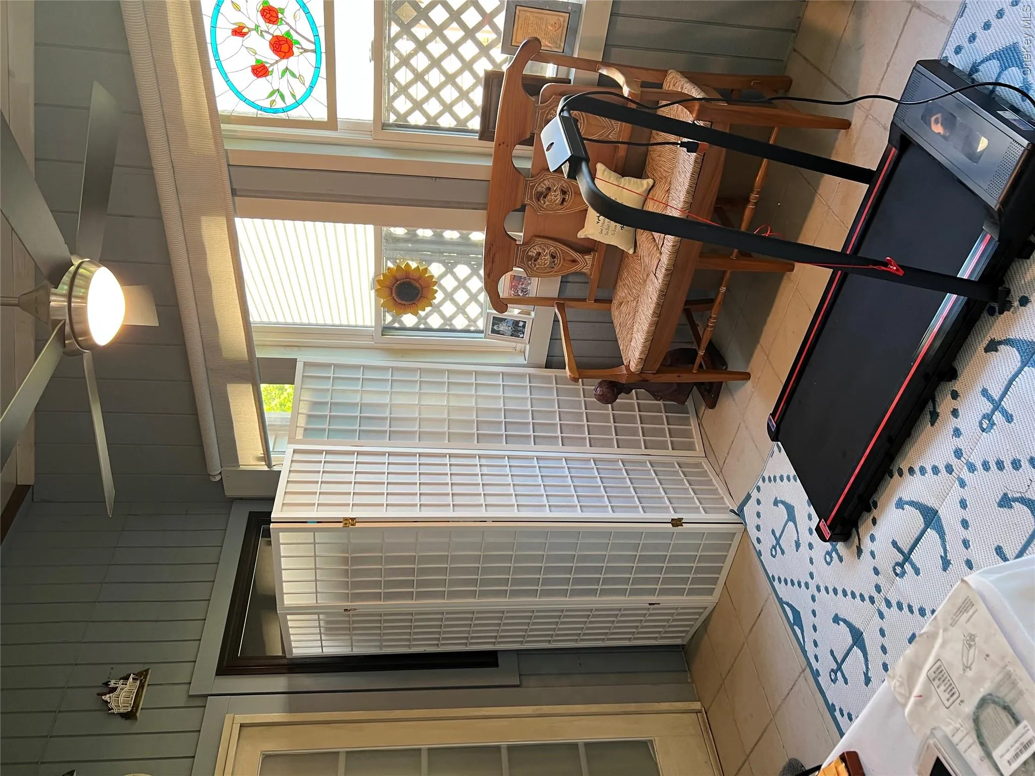 Sunroom featuring board and batten walls, tile flooring, and a ceiling fan with integrated lighting Sunroom featuring board and batten walls, tile flooring, and a ceiling fan with integrated lighting