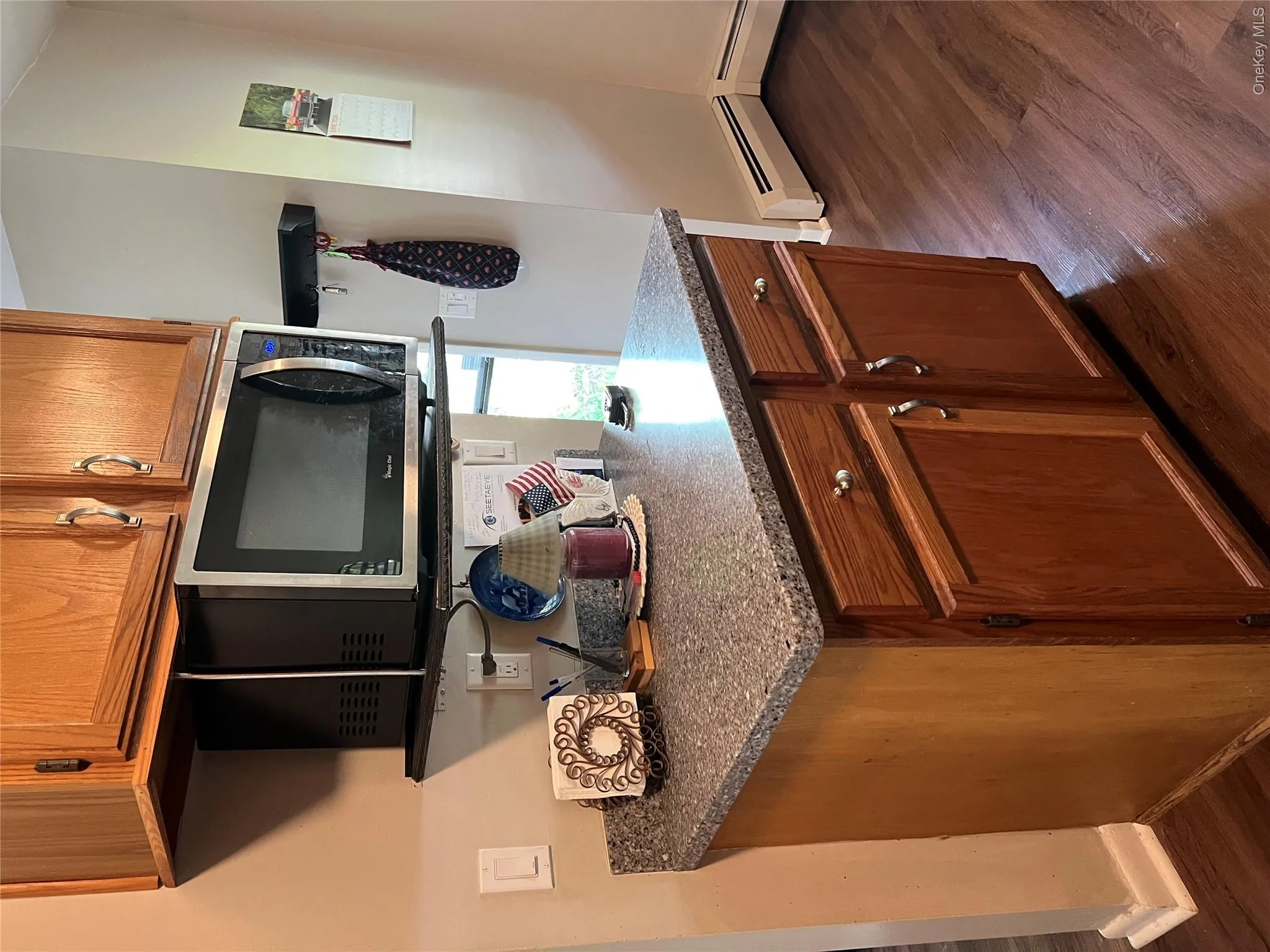 Wood-finish flooring complementing a built-in cabinet with a speckled countertop Wood-finish flooring complementing a built-in cabinet with a speckled countertop
