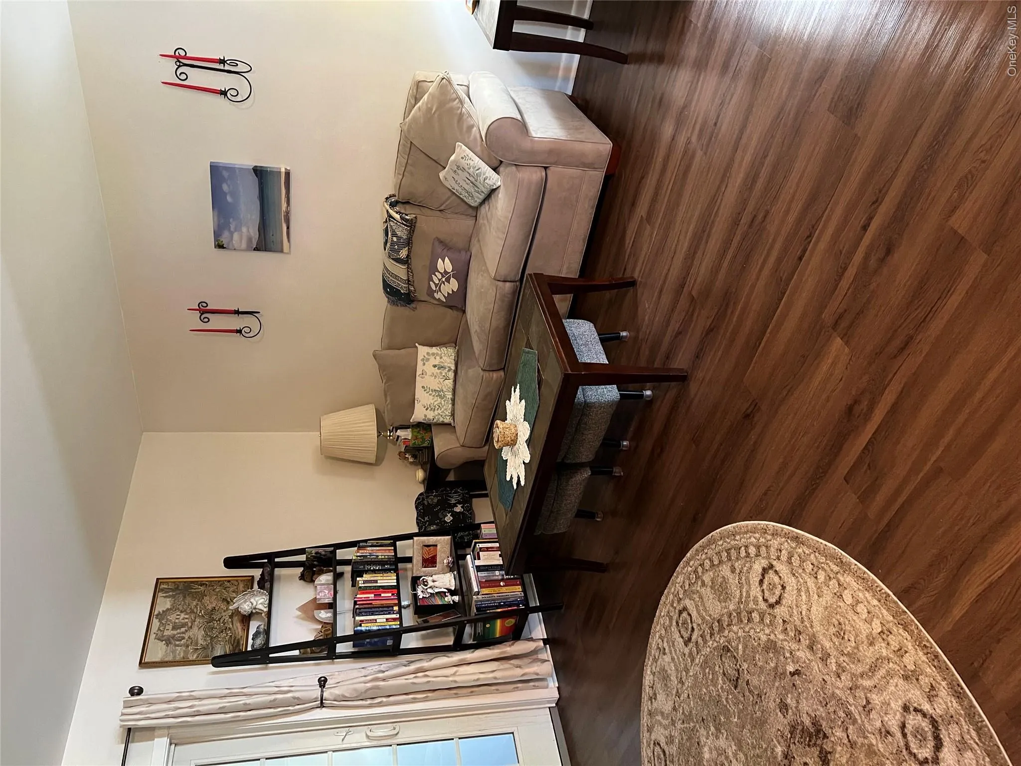 Spacious interior with rich wood-finish flooring, light-toned walls, and a built-in shelving unit Spacious interior with rich wood-finish flooring, light-toned walls, and a built-in shelving unit