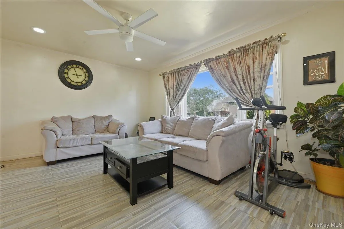 Living area featuring light-toned tile flooring, a ceiling fan with integrated lighting, and recessed ceiling lights Living area featuring light-toned tile flooring, a ceiling fan with integrated lighting, and recessed ceiling lights