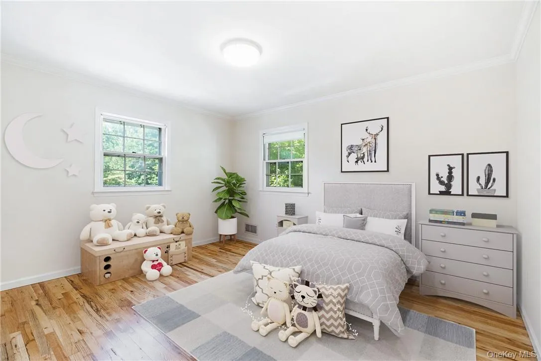 Bedroom with ornamental molding and light hardwood / wood-style flooring Bedroom with ornamental molding and light hardwood / wood-style flooring