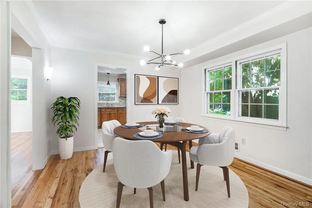 Dining room with a chandelier, crown molding, sink, and light wood-type flooring Dining room with a chandelier, crown molding, sink, and light wood-type flooring