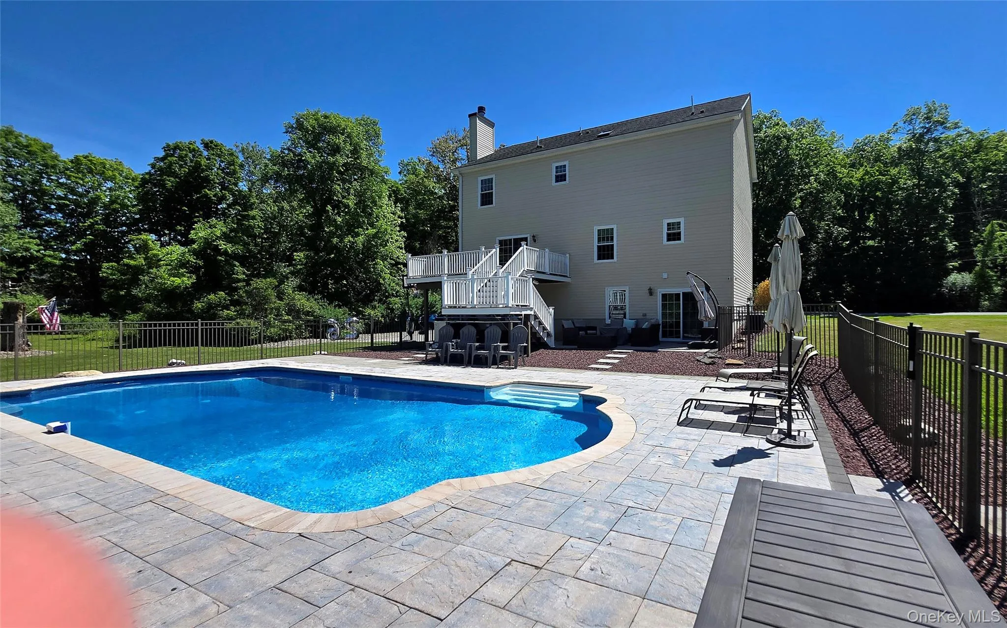 Back view of complete deck accessing the fully fenced pool and sunning area. Back view of complete deck accessing the fully fenced pool and sunning area.