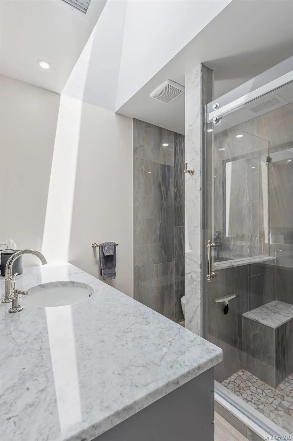 Another View Of The Magnificent Primary Bathroom Which Has Been Gutted Down To The Studs & Offers A Spectacular Oversized Custom Shower With All 24" x 48" Stone Tiled Walls, Built In L Shaped Seat, Pebble Stone Style Floor, Wheeled/Rolling Frameless Glass Doors, High End Shower Fittings, Separate Commode Area With Fully Stone Tiled Walls, Stone Topped Handmade Custom Vanity, Wide Length Porcelain Plank Tile Floors, Skylight & All High End Details/Trims. Another View Of The Magnificent Primary Bathroom Which Has Been Gutted Down To The Studs & Offers A Spectacular Oversized Custom Shower With All 24" x 48" Stone Tiled Walls, Built In L Shaped Seat, Pebble Stone Style Floor, Wheeled/Rolling Frameless Glass Doors, High End Shower Fittings, Separate Commode Area With Fully Stone Tiled Walls, Stone Topped Handmade Custom Vanity, Wide Length Porcelain Plank Tile Floors, Skylight & All High End Details/Trims.