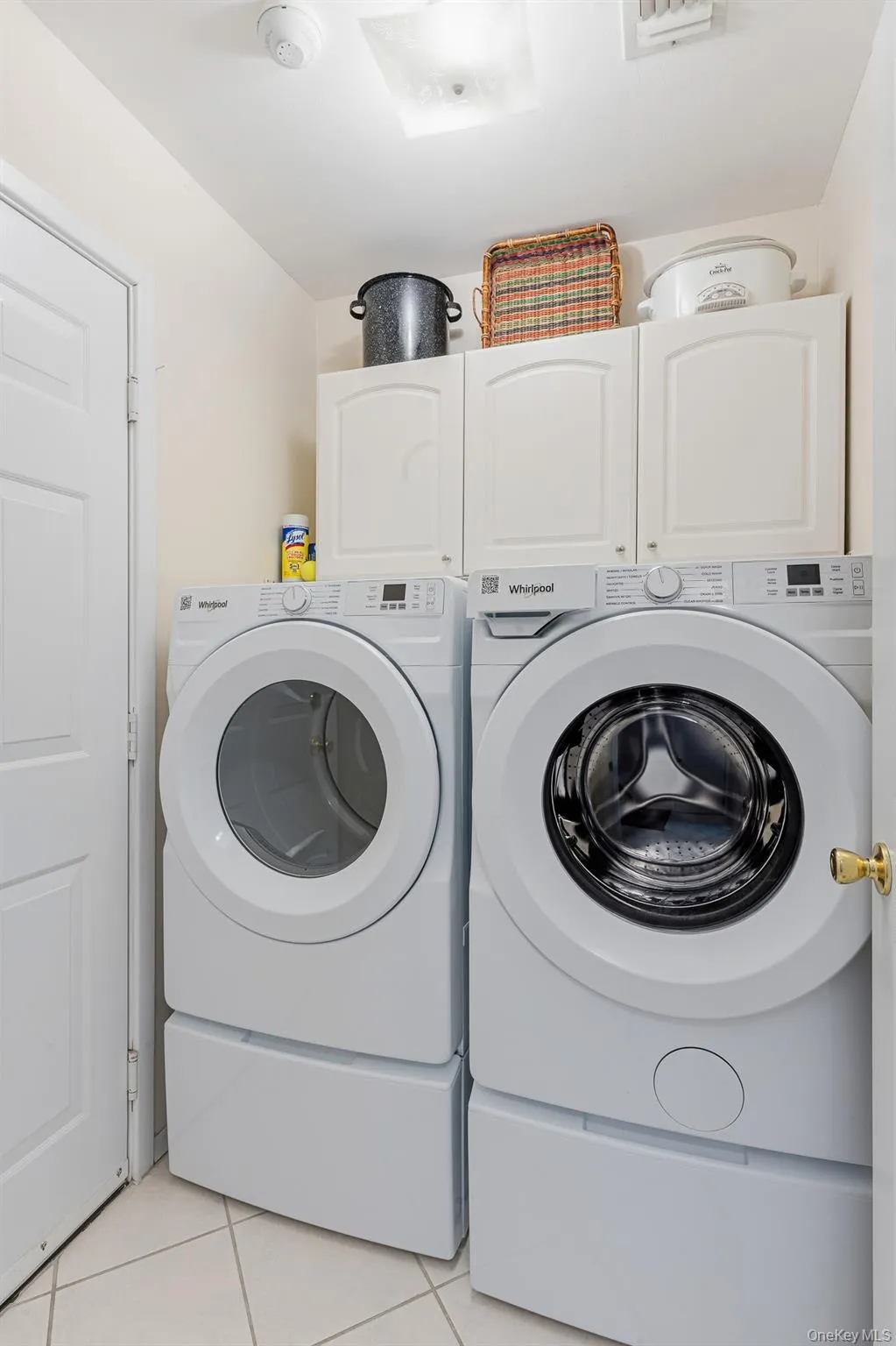 A Laundry/Mud Room Offers A Brand New Front Loading Whirlpool Washer & Dryer With Drawers Below & Additional Storage Cabinetry Above, Diagonal Ceramic Tiled Floors & Access To The Attached Garage. A Laundry/Mud Room Offers A Brand New Front Loading Whirlpool Washer & Dryer With Drawers Below & Additional Storage Cabinetry Above, Diagonal Ceramic Tiled Floors & Access To The Attached Garage.