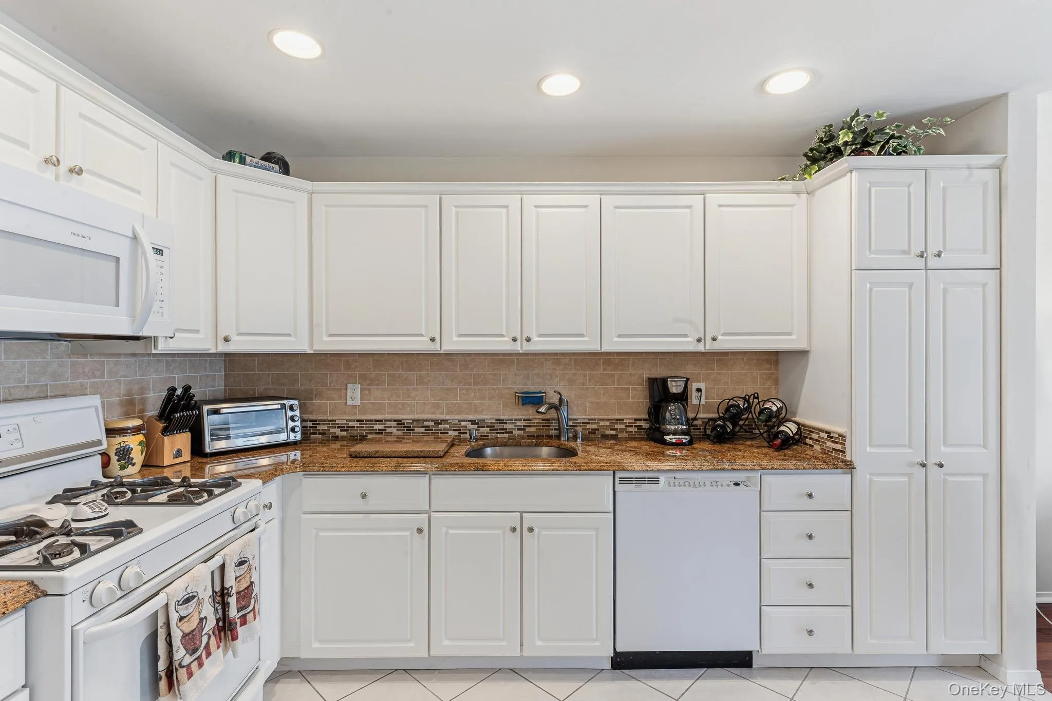 The Beautifully Upgraded Eat In Kitchen Offers Walls Of White Raised Panel Cabinetry, Beautiful Crown Moldings, Bullnose Edged Granite Countertops With An Undermount Sink, Accent Tiled Backsplash With Both Ceramic Tile & Glass/Mosaic Tile, Frigidaire Gas Stove, Built In Microwave Oven, Two Year Old Frigidaire Side By Side Refrigerator With Water & ice Maker, Frigidaire Dishwasher, Large Built In Pantry, Recessed Lighting, Diagonal Ceramic Tile Floors, And The Kitchen Opens Into The Great Room. The Beautifully Upgraded Eat In Kitchen Offers Walls Of White Raised Panel Cabinetry, Beautiful Crown Moldings, Bullnose Edged Granite Countertops With An Undermount Sink, Accent Tiled Backsplash With Both Ceramic Tile & Glass/Mosaic Tile, Frigidaire Gas Stove, Built In Microwave Oven, Two Year Old Frigidaire Side By Side Refrigerator With Water & ice Maker, Frigidaire Dishwasher, Large Built In Pantry, Recessed Lighting, Diagonal Ceramic Tile Floors, And The Kitchen Opens Into The Great Room.