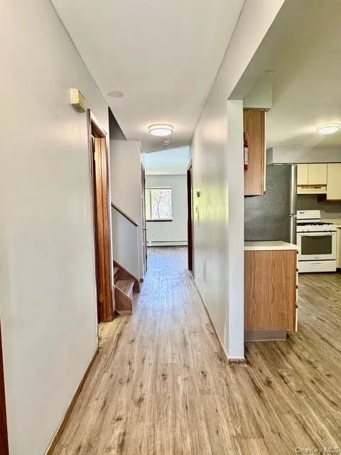 with side view of kitchen, steps leading upstairs, dining area and living room. with side view of kitchen, steps leading upstairs, dining area and living room.