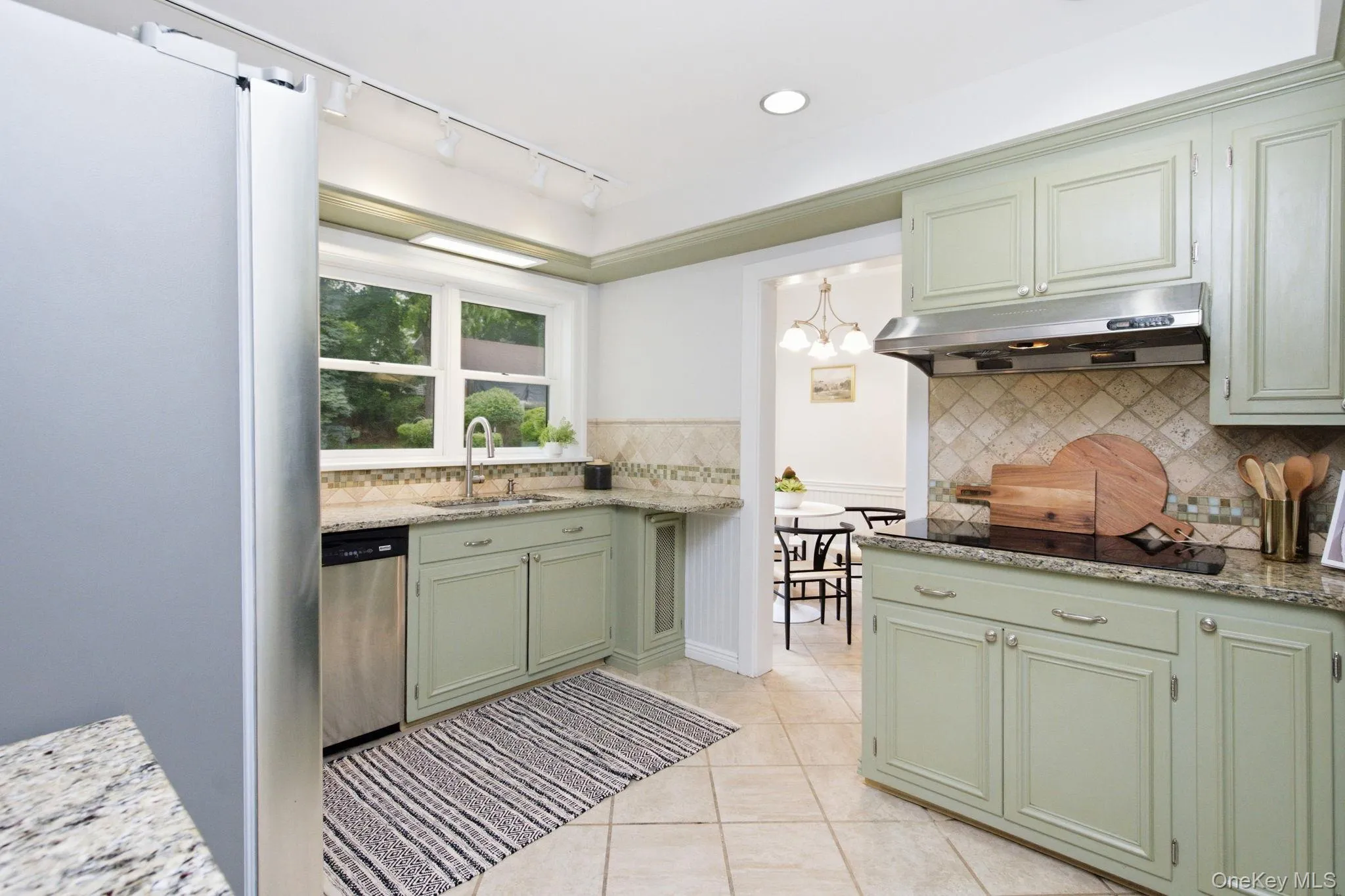 The granite kitchen pairs stainless appliances with a tile backsplash. The granite kitchen pairs stainless appliances with a tile backsplash.