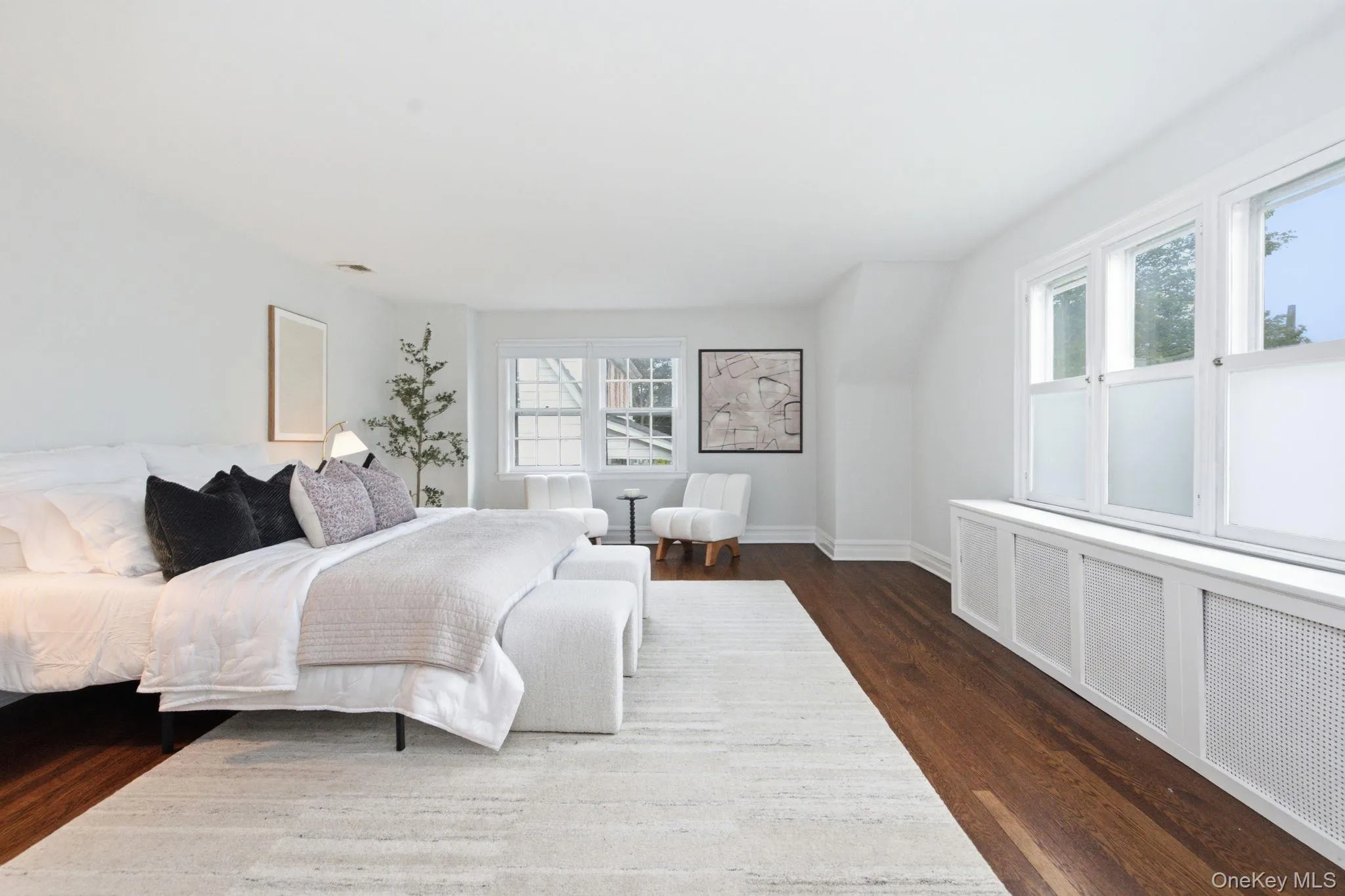 Dual exposures and gleaming wood floors define this serene primary bedroom. Dual exposures and gleaming wood floors define this serene primary bedroom.