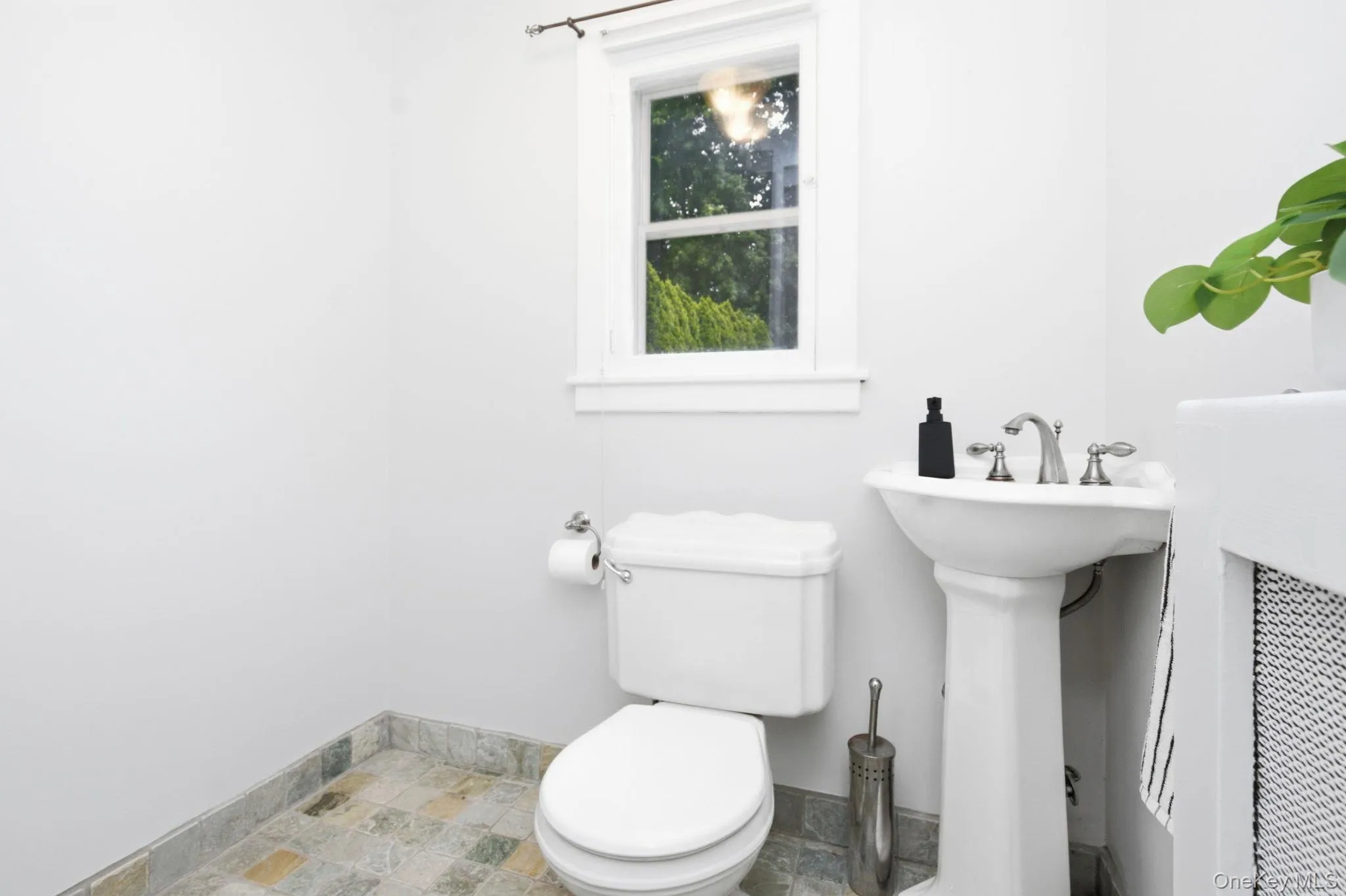 The adjoining half bath features a pedestal sink and tile floor. The adjoining half bath features a pedestal sink and tile floor.