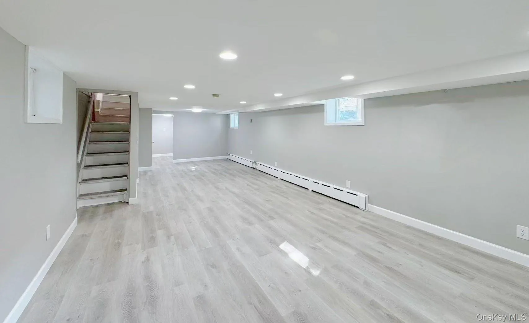 Expansive finished lower level featuring light wood-finish flooring, recessed lighting, and neutral wall tones Expansive finished lower level featuring light wood-finish flooring, recessed lighting, and neutral wall tones