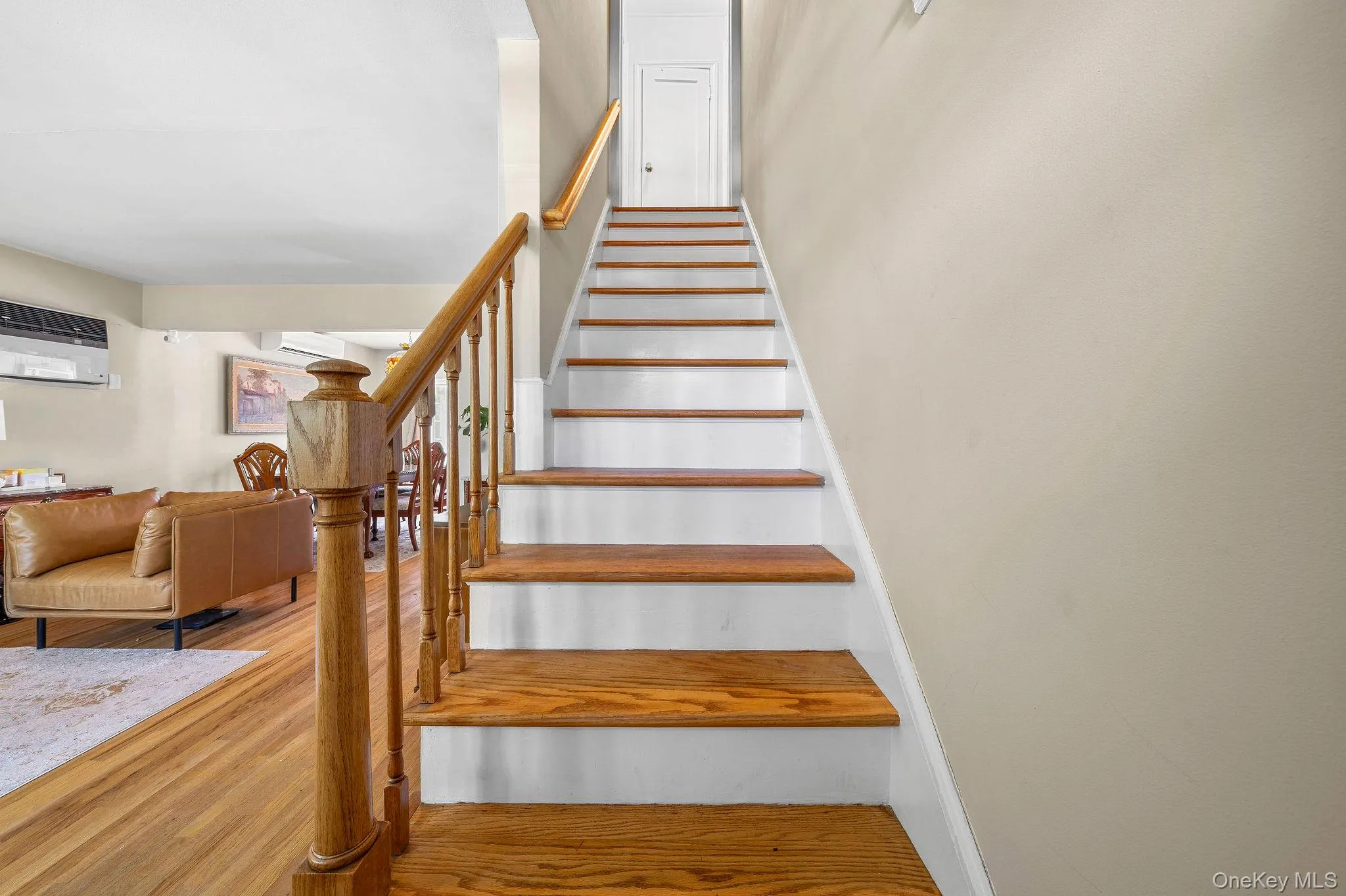 Hardwood staircase featuring white risers and a wood-finish handrail Hardwood staircase featuring white risers and a wood-finish handrail
