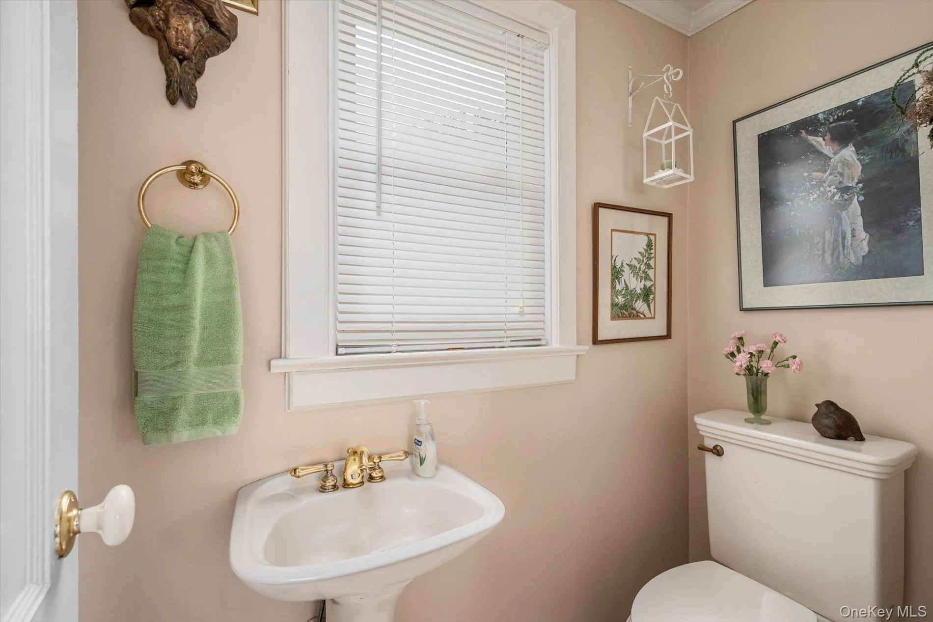 Pedestal sink with brass-finish faucet fixtures Pedestal sink with brass-finish faucet fixtures