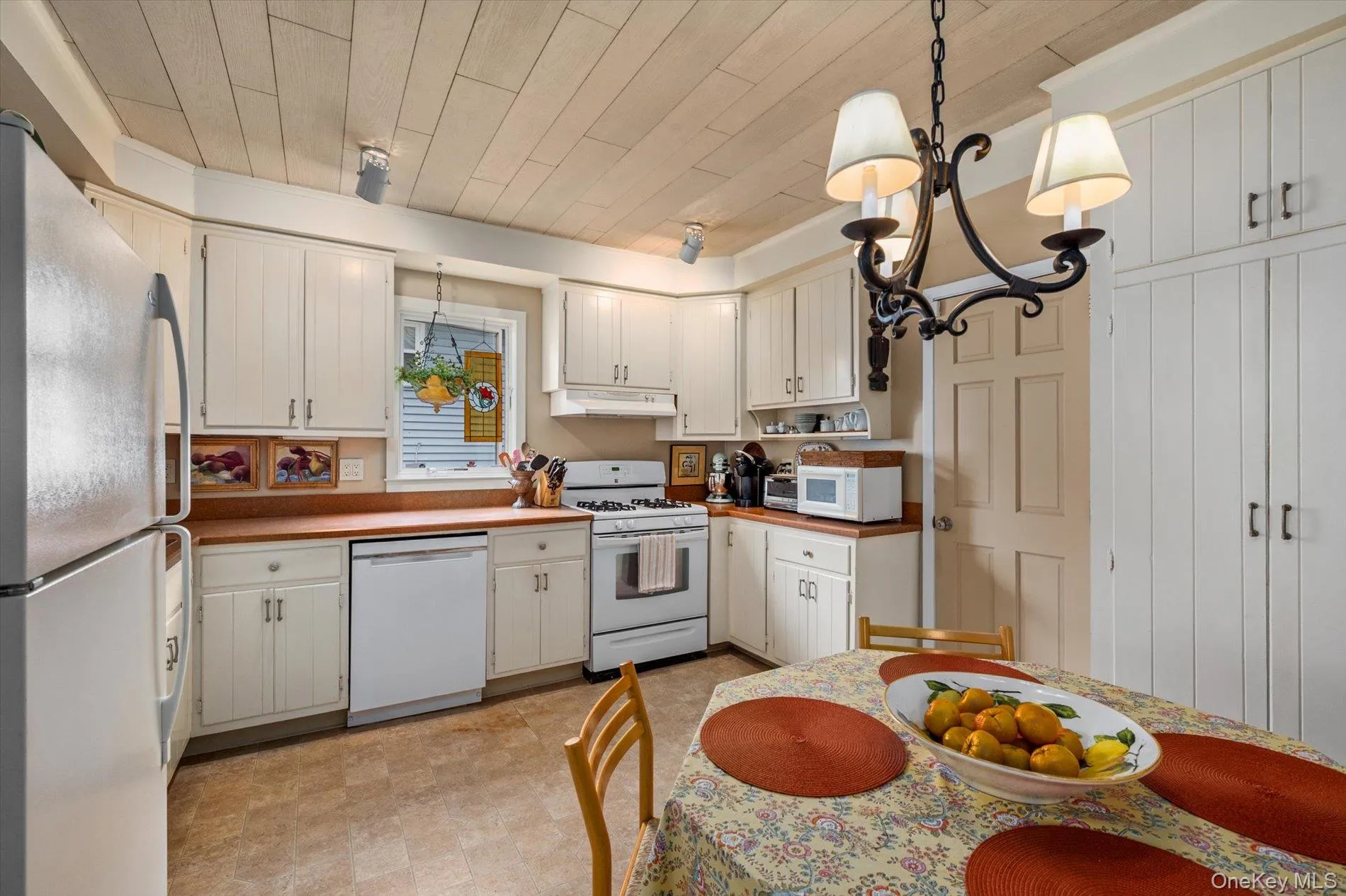 Kitchen featuring wood-finish flooring, white cabinetry, and wood countertops Kitchen featuring wood-finish flooring, white cabinetry, and wood countertops