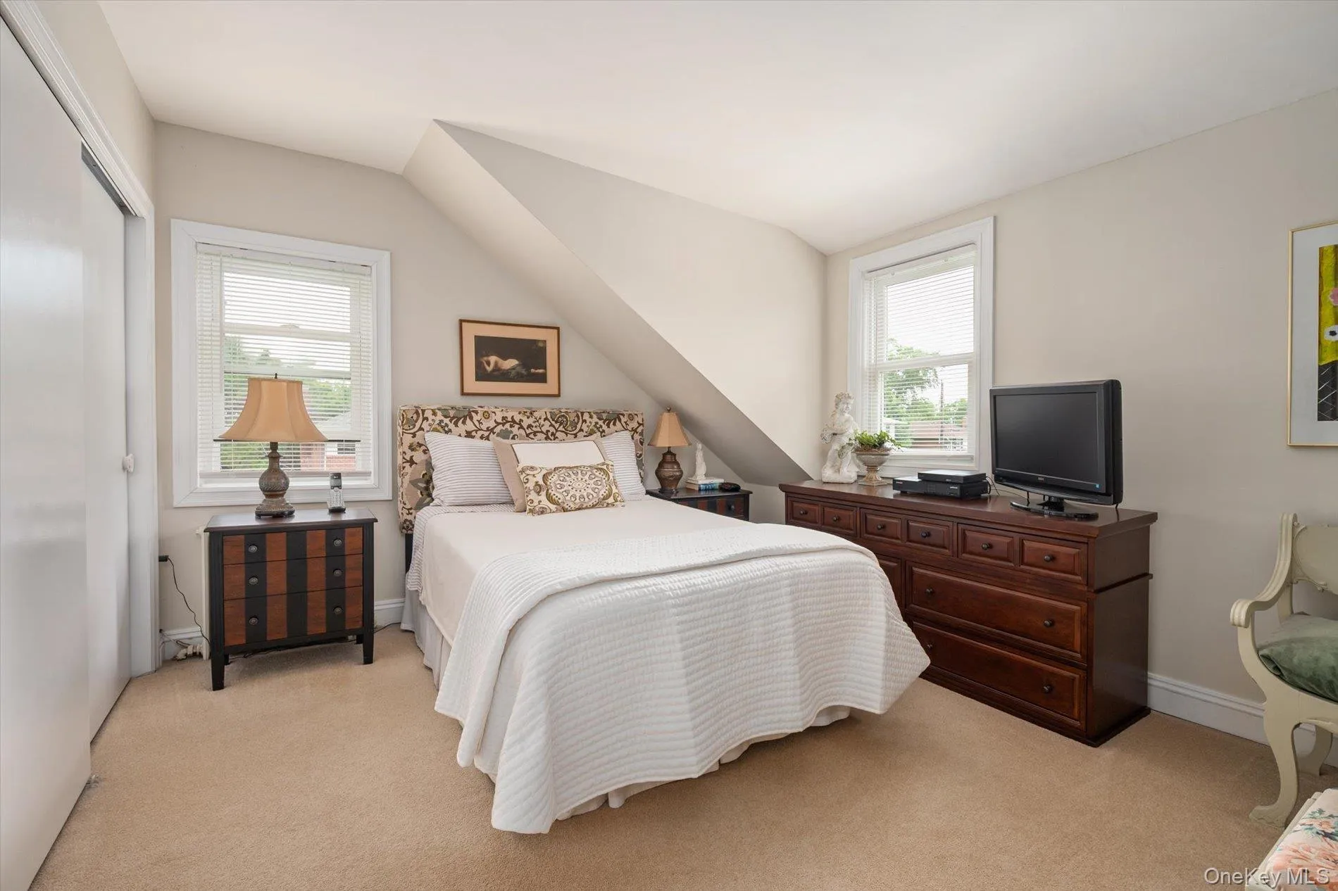 Carpeted room featuring sloped ceilings and two double-hung windows Carpeted room featuring sloped ceilings and two double-hung windows