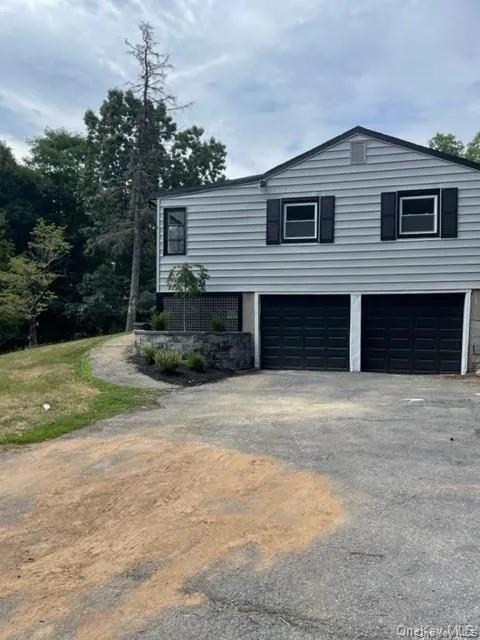 View of side of home featuring a garage View of side of home featuring a garage