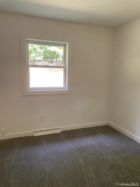 Empty room featuring dark colored carpet Empty room featuring dark colored carpet