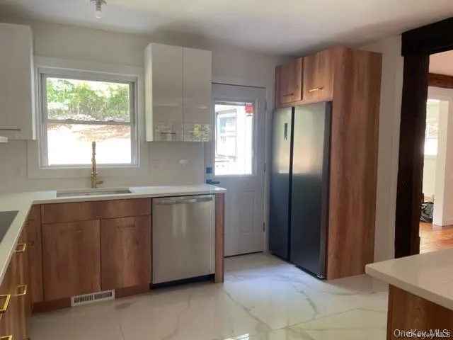 Kitchen featuring sink, light tile floors, and stainless steel appliances Kitchen featuring sink, light tile floors, and stainless steel appliances