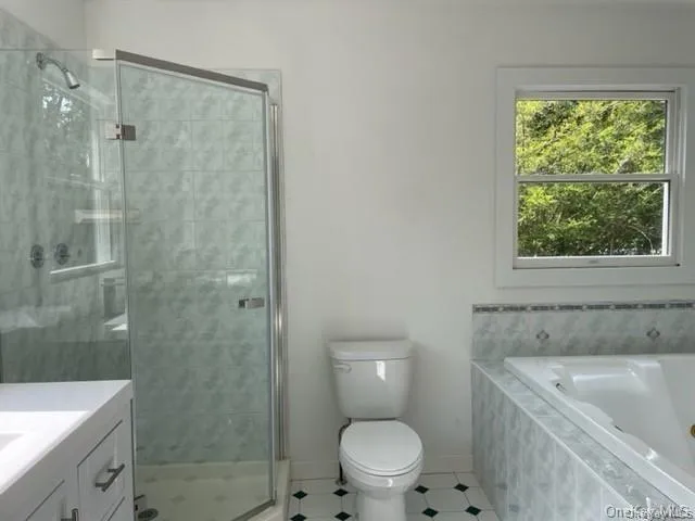 Full bathroom featuring tile floors, plus walk in shower, vanity, and toilet Full bathroom featuring tile floors, plus walk in shower, vanity, and toilet
