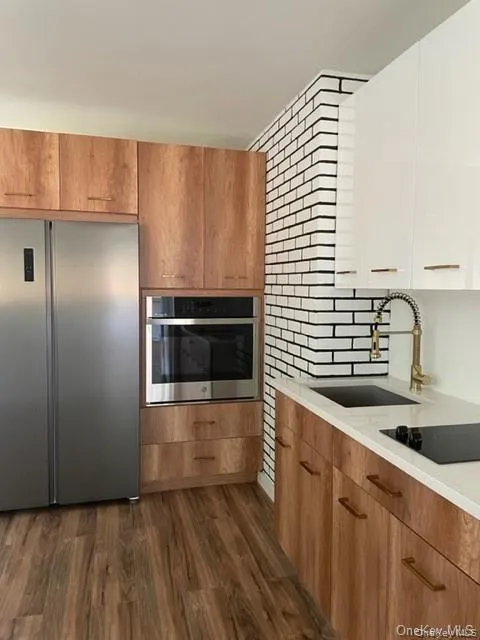 Kitchen featuring appliances with stainless steel finishes, sink, and dark hardwood / wood-style floors Kitchen featuring appliances with stainless steel finishes, sink, and dark hardwood / wood-style floors