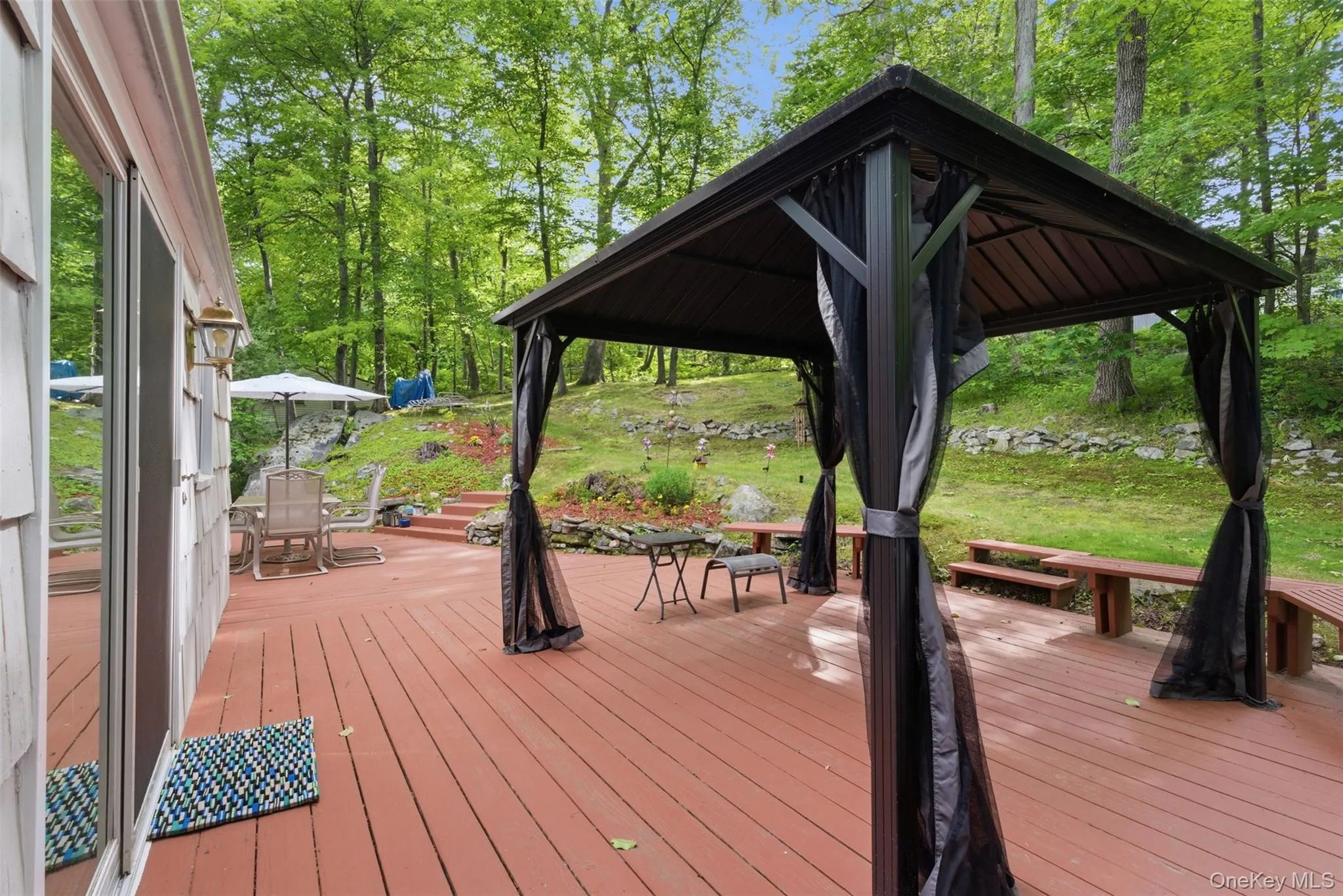 Expansive deck with covered gazebo is accessed from the dining room/kitchen Expansive deck with covered gazebo is accessed from the dining room/kitchen