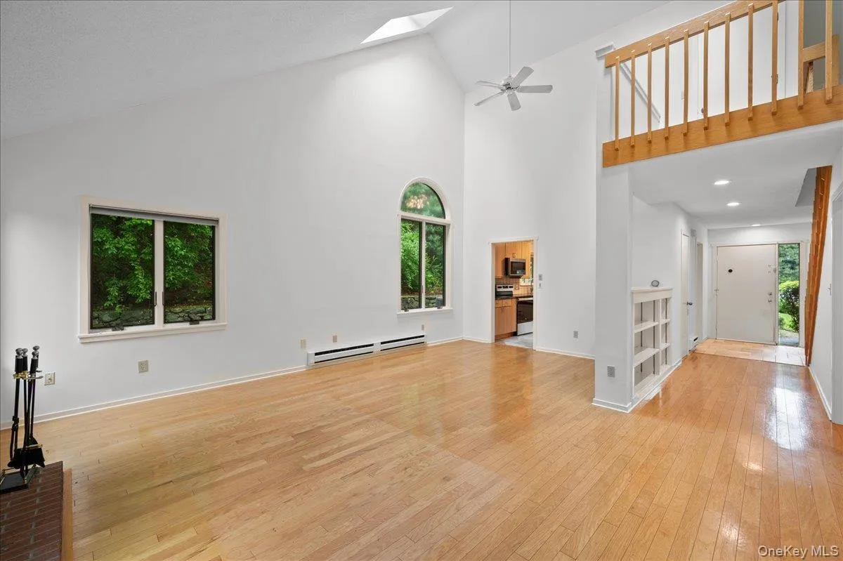 Living room with vaulted ceilings, built in book shelves, large windows, and skylights Living room with vaulted ceilings, built in book shelves, large windows, and skylights