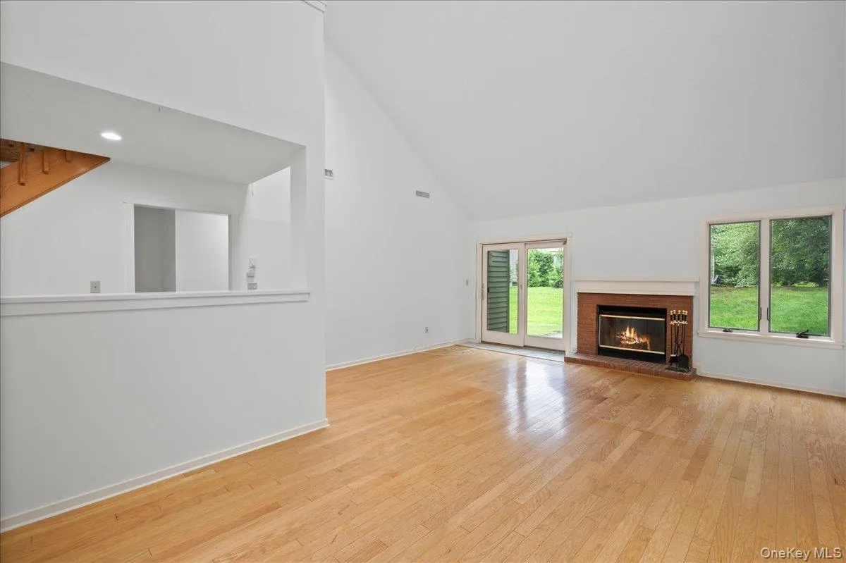 Living room with vaulted ceilings, dining area, large windows and skylights, and wood burning fireplace Living room with vaulted ceilings, dining area, large windows and skylights, and wood burning fireplace