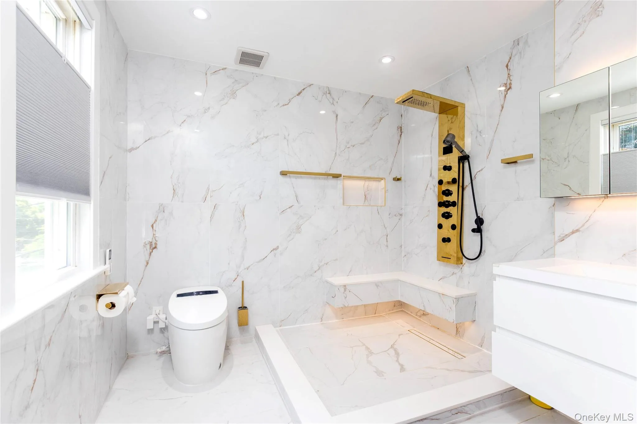 Modern bathroom featuring large-format wall and floor tiling with subtle veining Modern bathroom featuring large-format wall and floor tiling with subtle veining