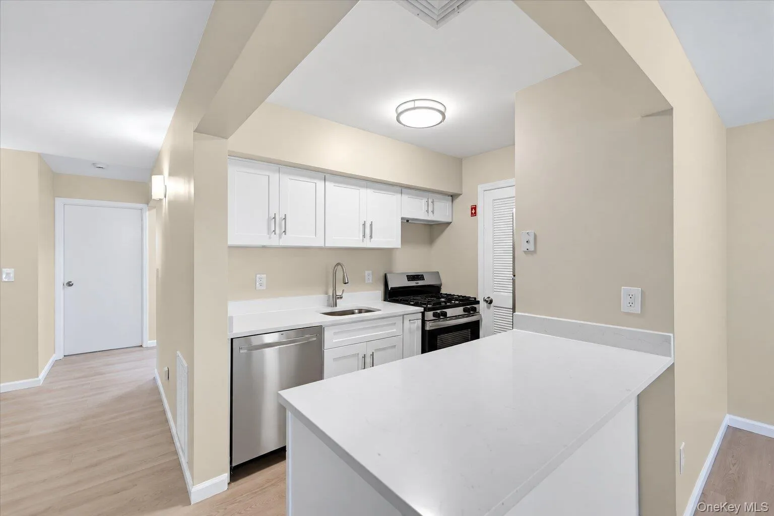 Bright kitchen featuring white cabinetry, stainless steel appliances, generous counter space, and an open breakfast bar. Bright kitchen featuring white cabinetry, stainless steel appliances, generous counter space, and an open breakfast bar.