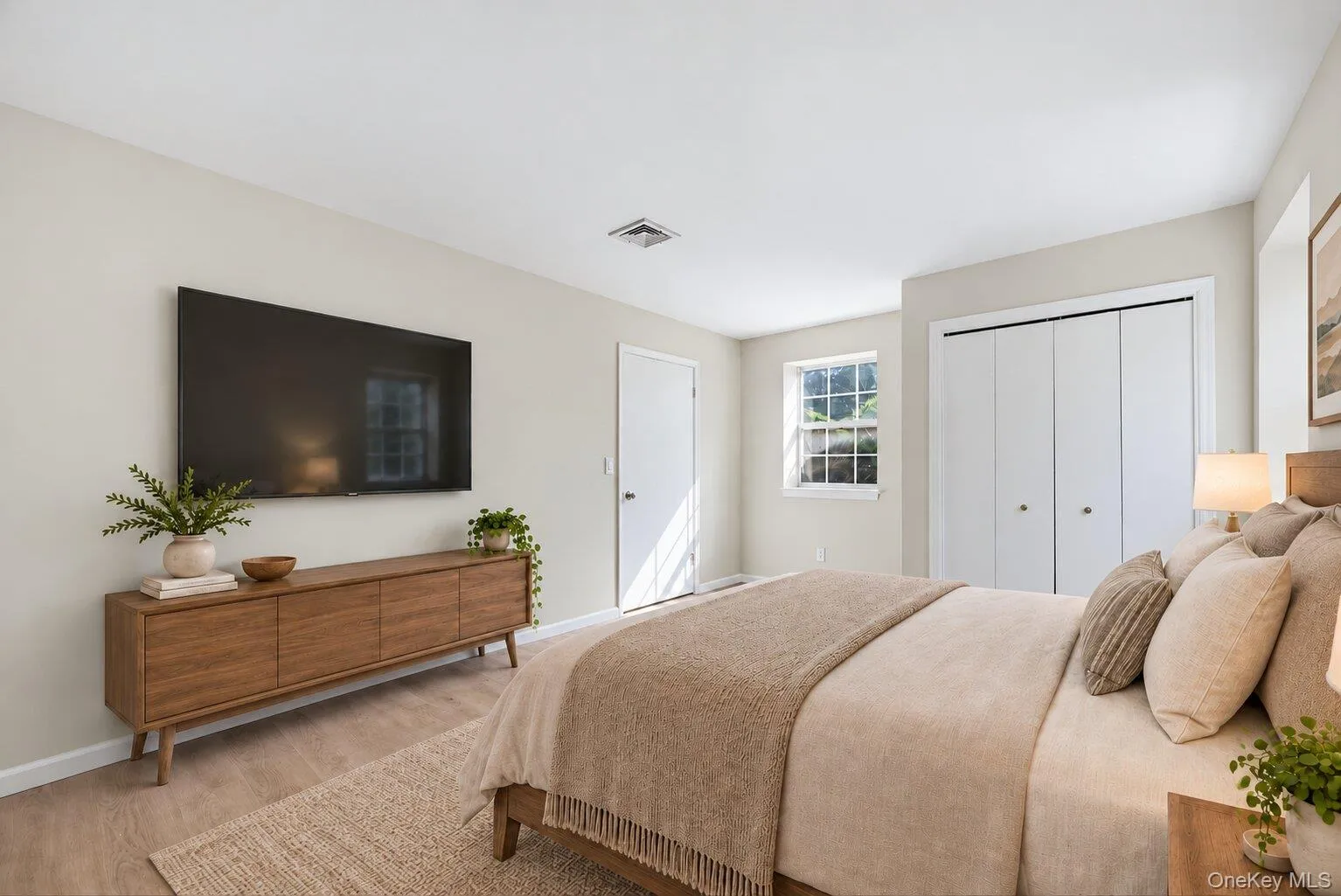 Virtually Staged. Spacious primary bedroom with light wood flooring, closet, window, and ample wall space. Virtually Staged. Spacious primary bedroom with light wood flooring, closet, window, and ample wall space.