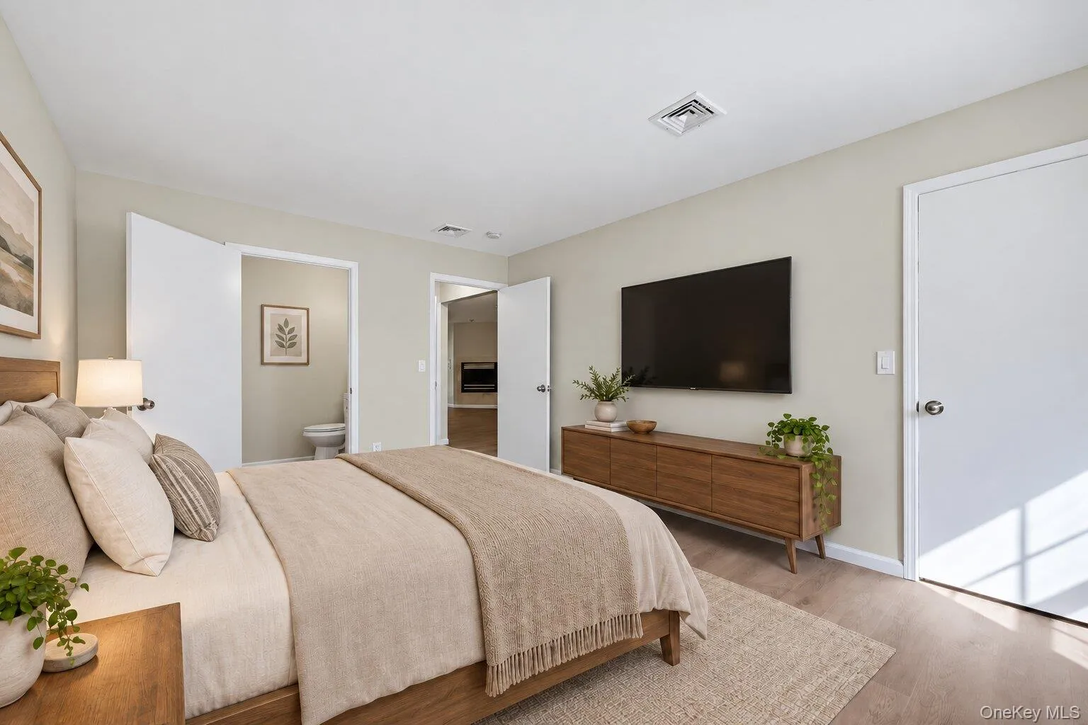 Virtually Staged. Alternate view of the primary bedroom showing access to an bathroom and the adjoining living area. Virtually Staged. Alternate view of the primary bedroom showing access to an bathroom and the adjoining living area.