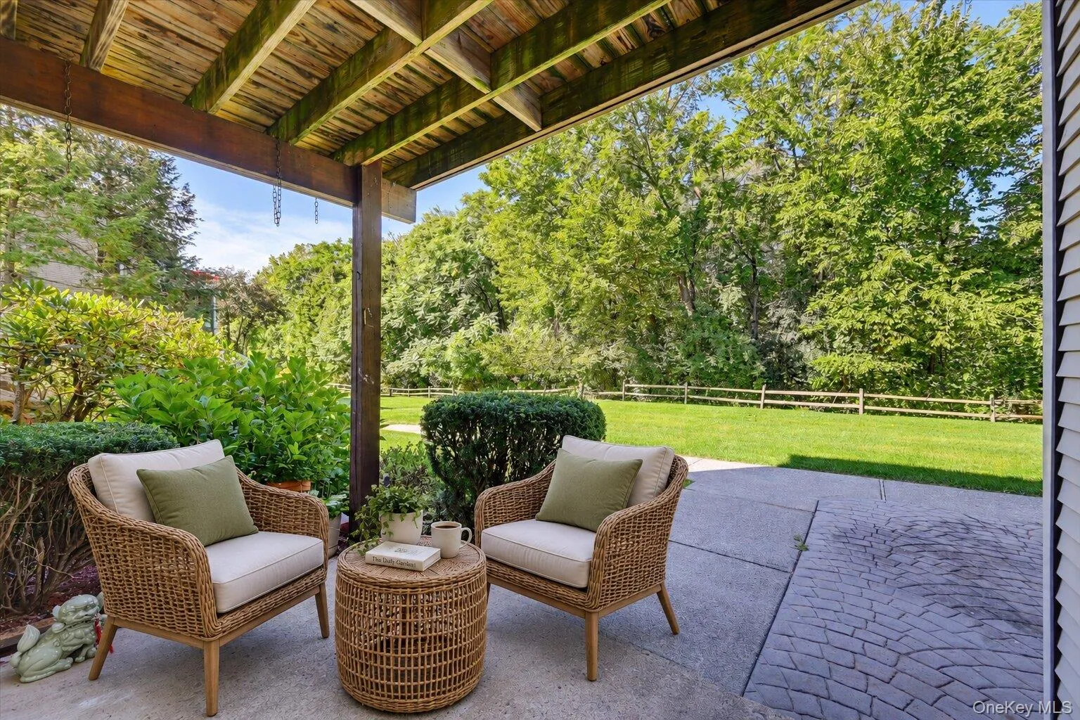 Virtually Staged. Covered patio area with seating, landscaped views, and access to the lawn. Virtually Staged. Covered patio area with seating, landscaped views, and access to the lawn.
