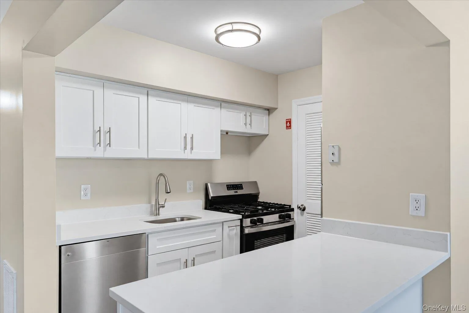 Updated kitchen with white cabinets, modern countertops, stainless steel appliances, and gas range. Updated kitchen with white cabinets, modern countertops, stainless steel appliances, and gas range.