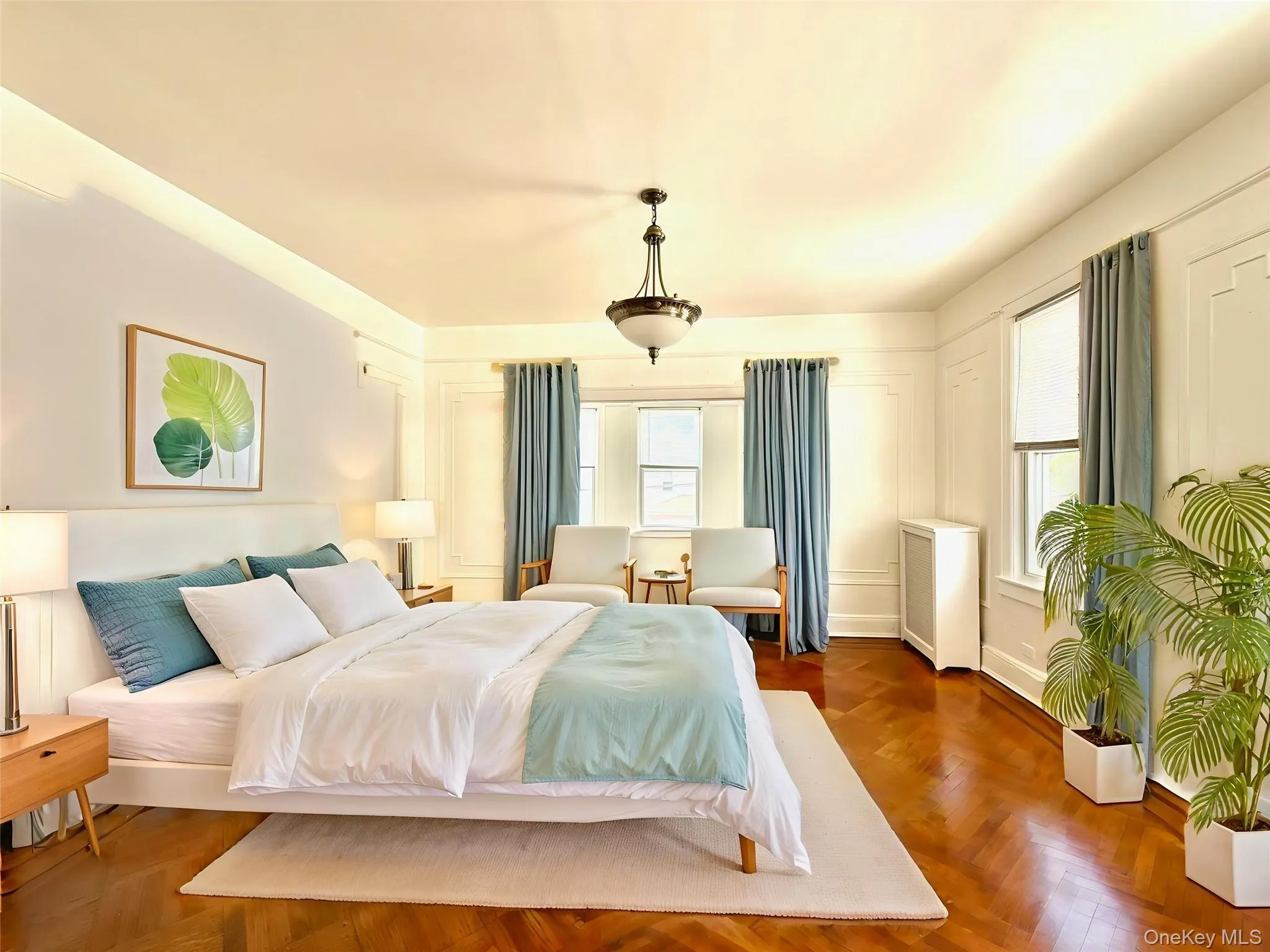 Spacious room featuring herringbone wood-finish flooring, recessed cove lighting, and multiple windows with custom drapery Spacious room featuring herringbone wood-finish flooring, recessed cove lighting, and multiple windows with custom drapery