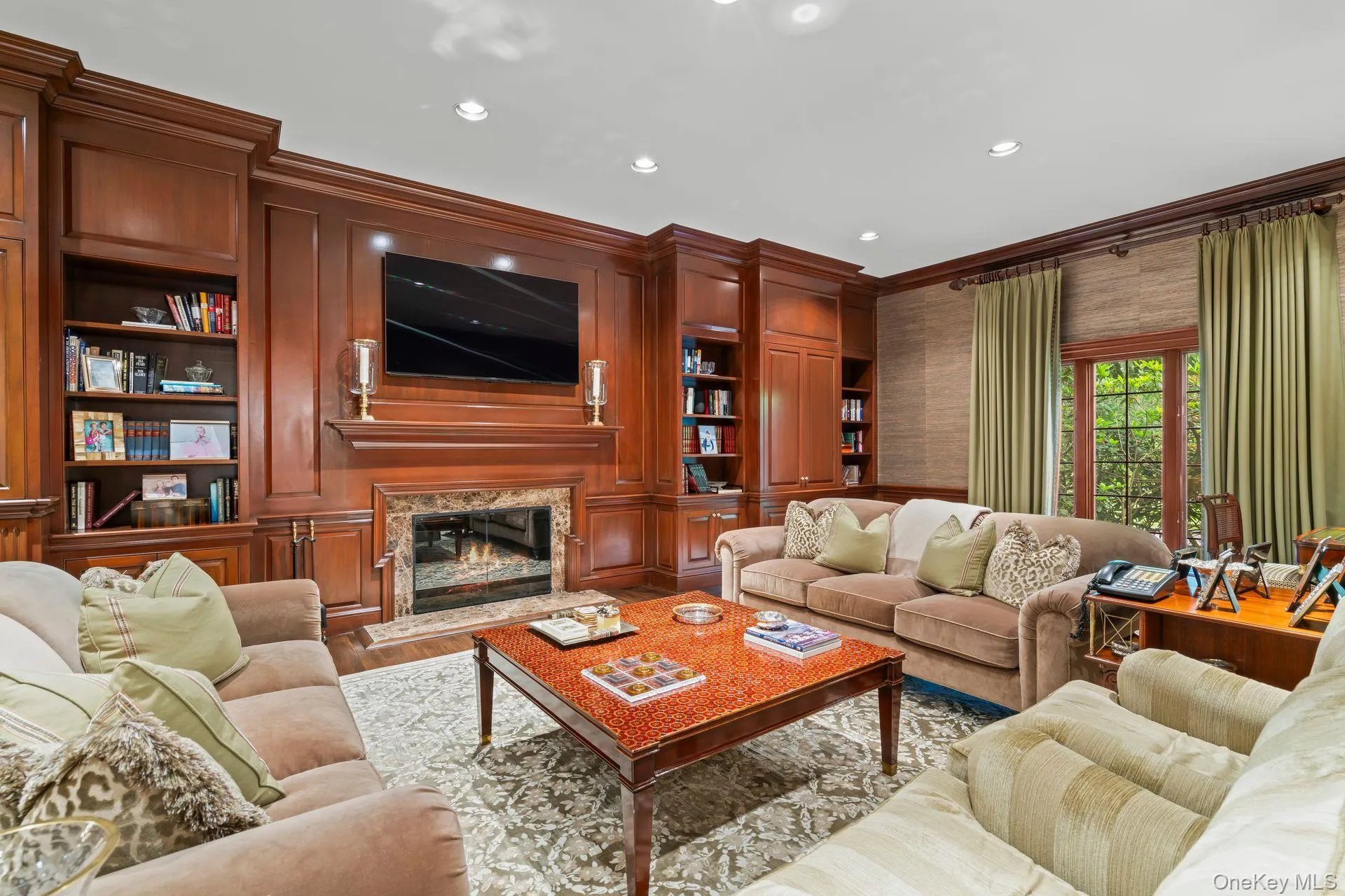 Living area featuring cherrywood finished floors, ornamental molding, recessed lighting, gas fireplace & custom cherrywood Built-in shelving Living area featuring cherrywood finished floors, ornamental molding, recessed lighting, gas fireplace & custom cherrywood Built-in shelving