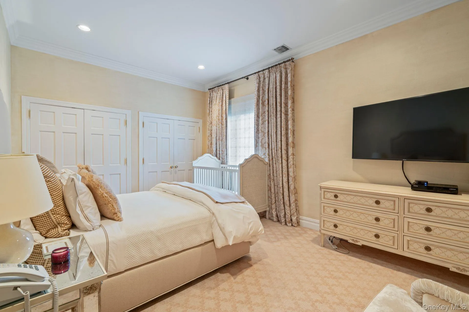 Bedroom featuring multiple closets, light colored carpet, crown molding, and recessed lighting, shared bath Bedroom featuring multiple closets, light colored carpet, crown molding, and recessed lighting, shared bath